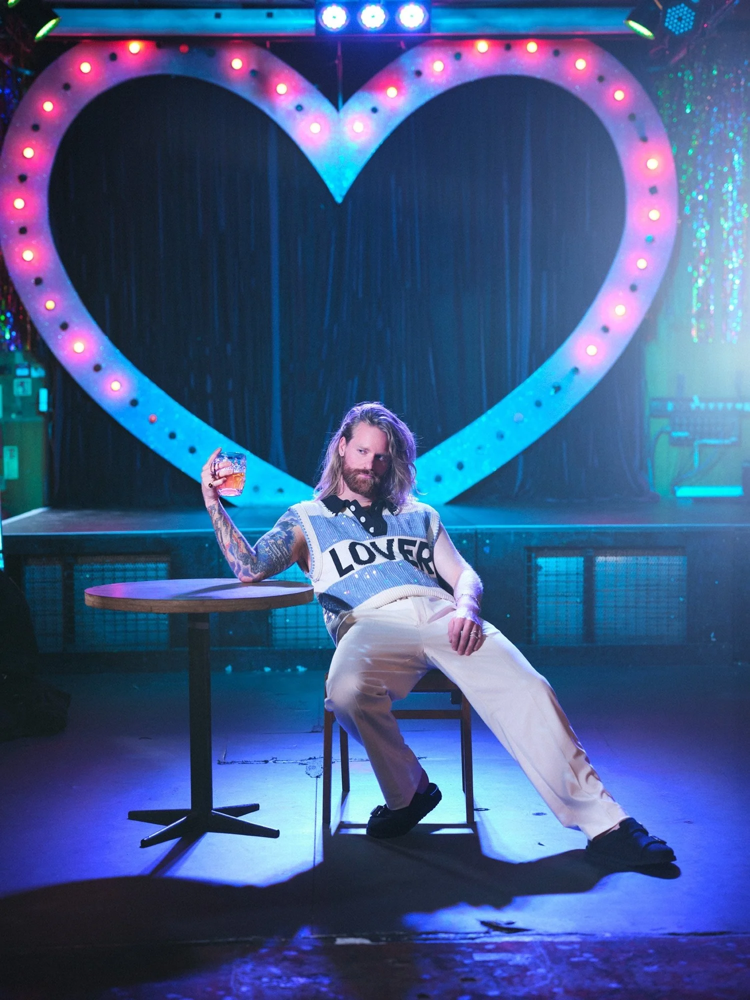Colourful portrait of English singer songwriter Sam Ryder with a pink neon heart, photographed by music photographer Chris Floyd