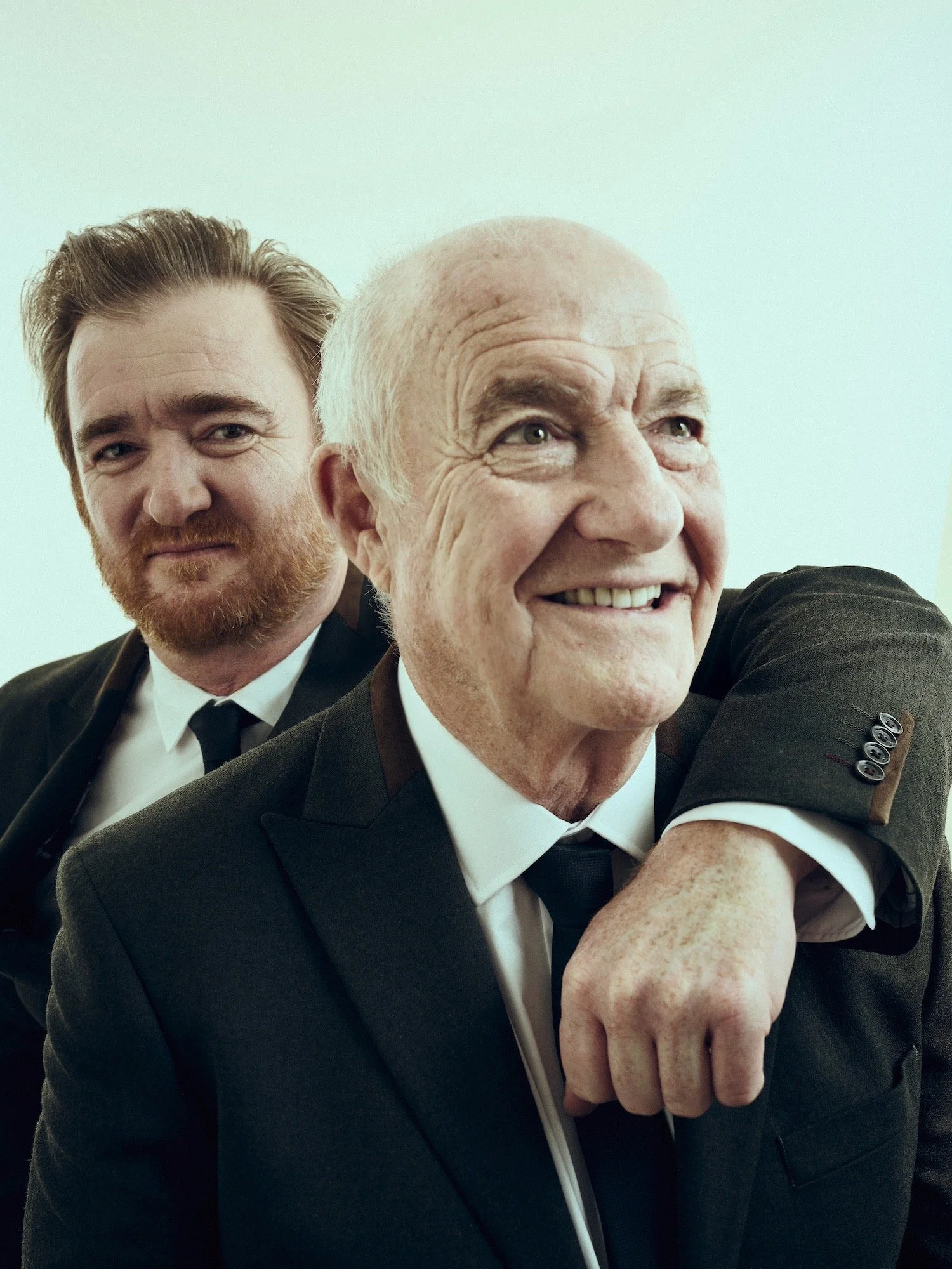 Studio portrait of chefs Rick Stein and Jack Stein in matching suits, captured with warmth and depth by Phil Fisk