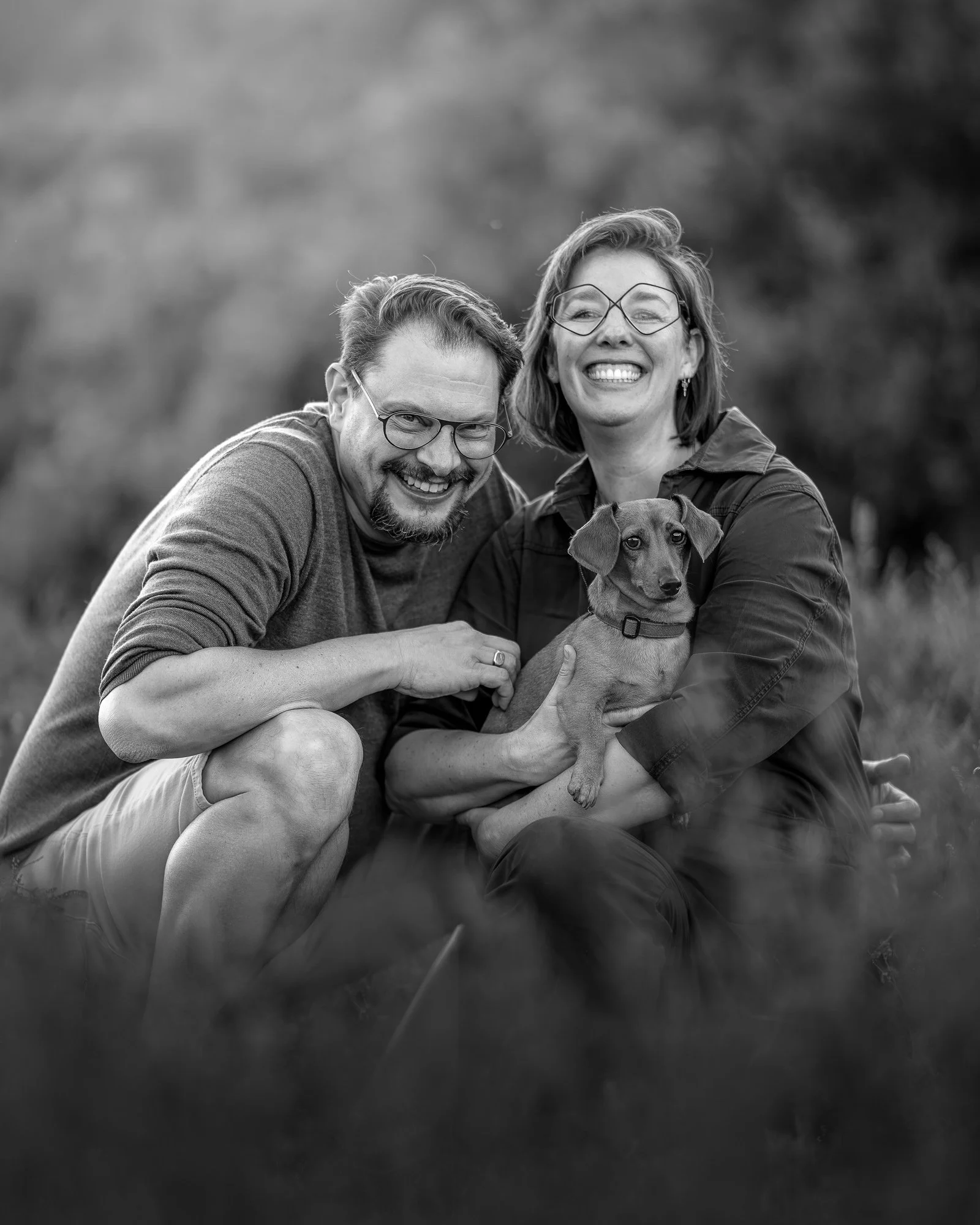 zwart-wit portret van teckel en twee eigenaren op de heide met focus op emotie en contrast