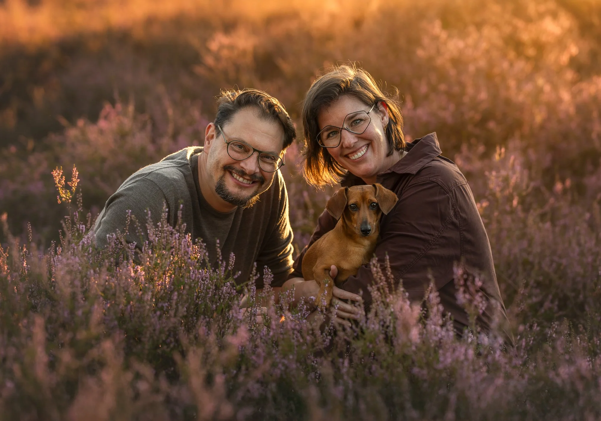eckel met twee eigenaren in de duinen vastgelegd in natuurlijk licht met zachte zandtinten en rustige sfeer