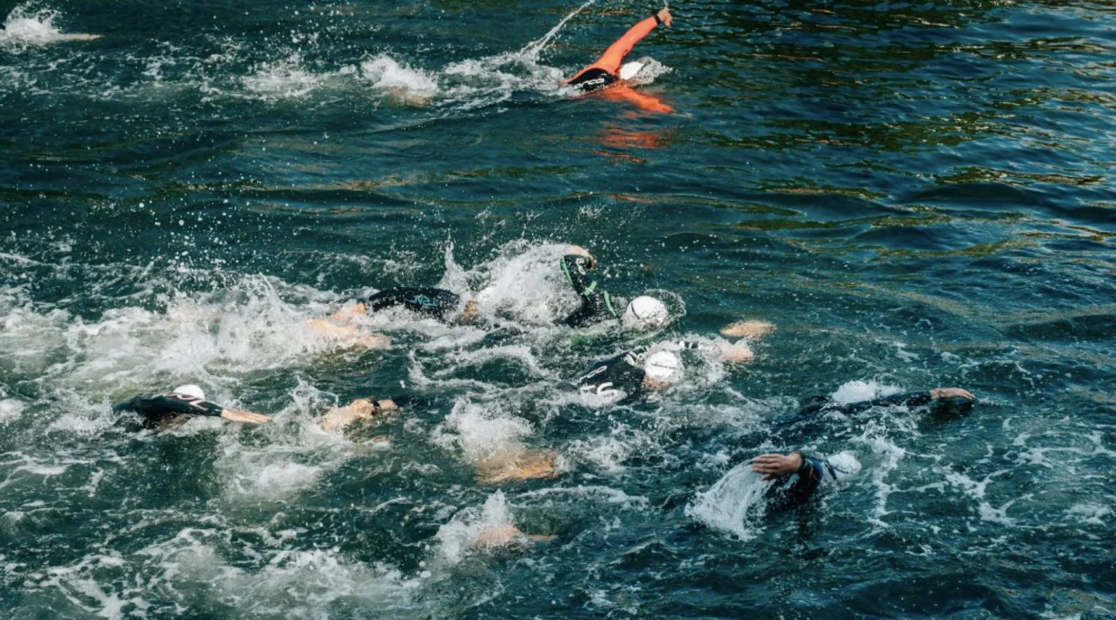 Open water swimmers navigating rough conditions, representing fear and challenge in endurance training.