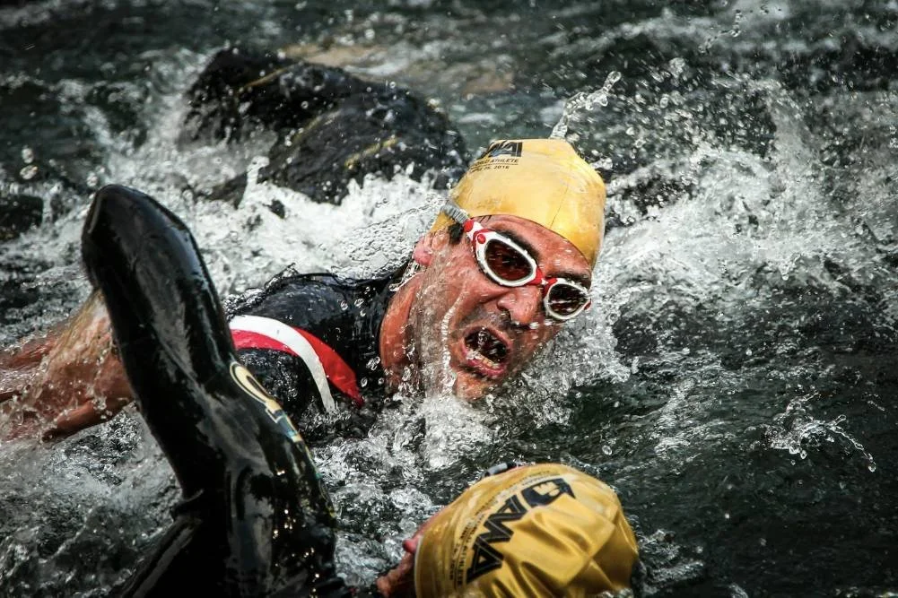 Triathletes swimming in open water while using Ironman training zones to guide race preparation and pacing