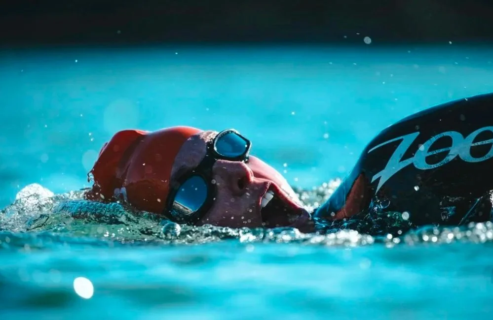 Triathlete swimming in open water during training, representing triathlon training zones across swim, bike and run.