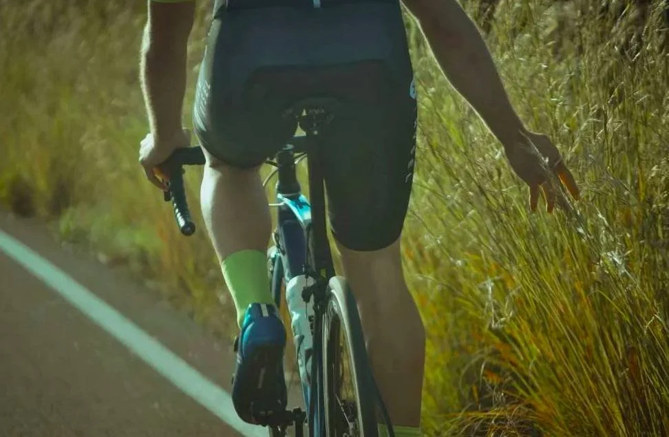 Un athlète pédalant seul sur une route dégagée, reflétant une motivation déclinante et une concentration renouvelée