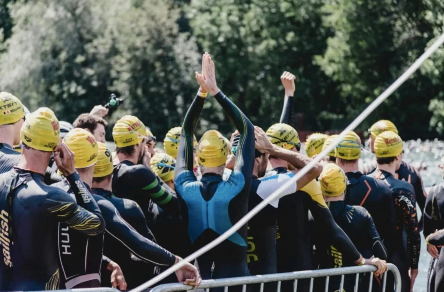 Triathletes in wetsuits preparing for an open water swim as part of Zone 1 active recovery training.