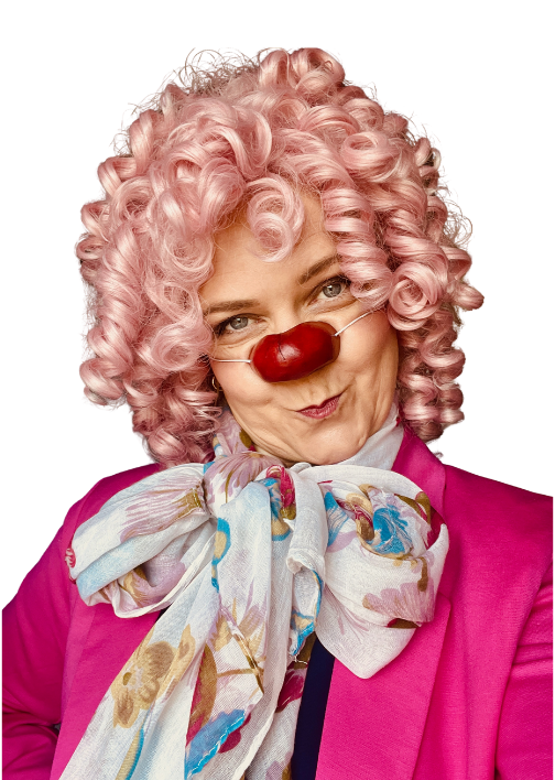 Woman dressed as a clown with pink curly wig, red nose glasses, colorful scarf, and a pink jacket.