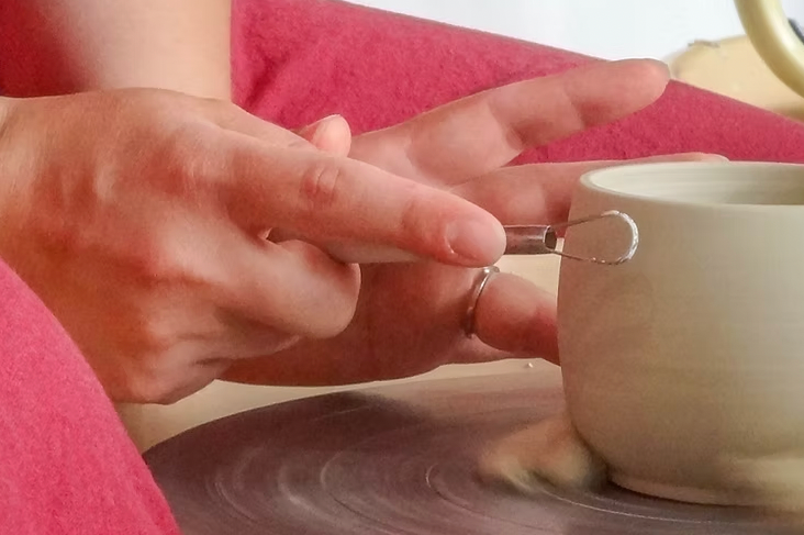 Tournassage d'une tasse avec une mirette sur un tour de potier