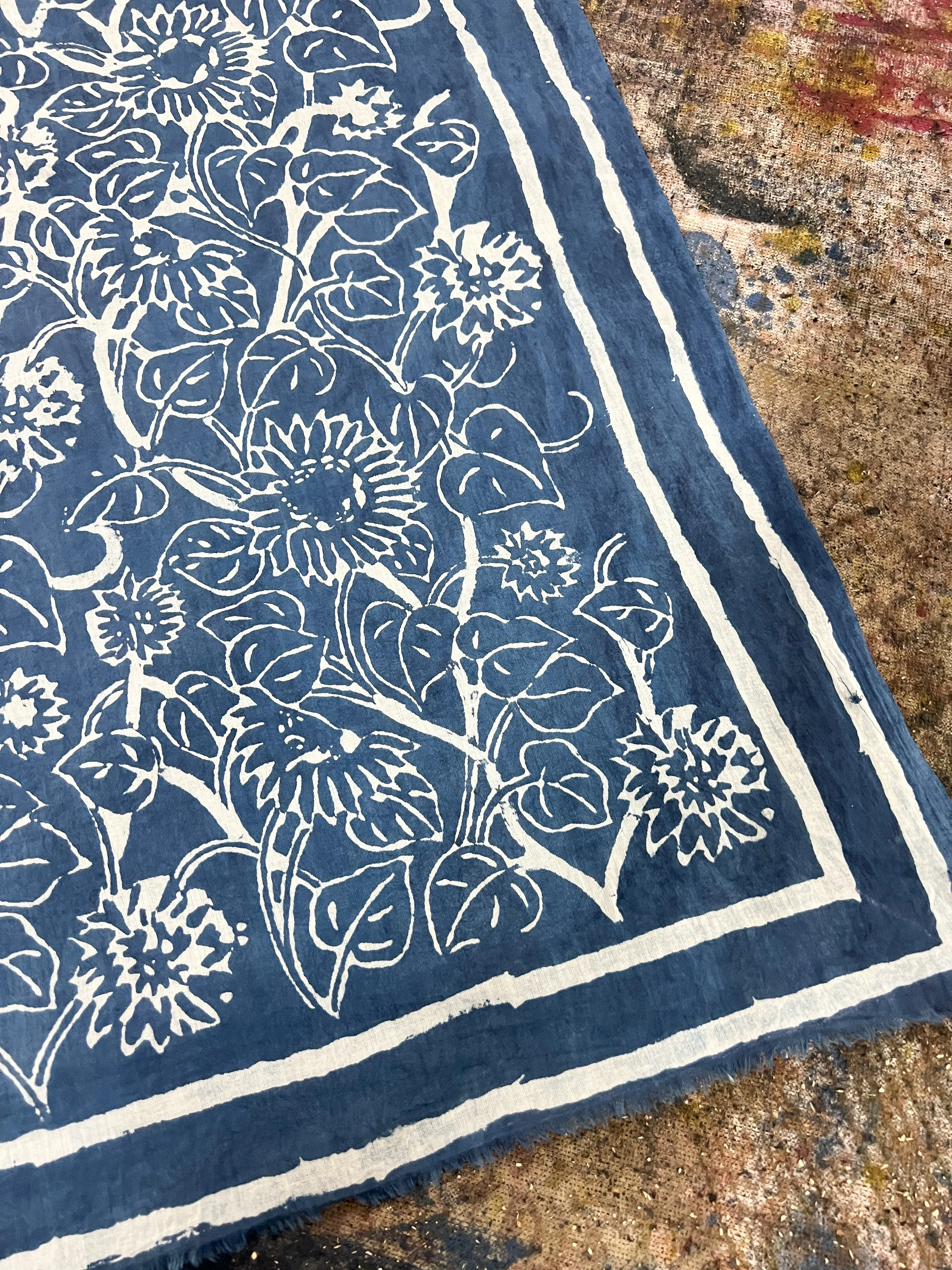 Indigo and white hand block printed cotton with a floral pattern and striped border, printed by Lizane Louw in the Dabu tradition in Bagru, Rajasthan.