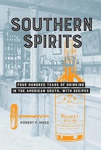 Cover of the book titled Southern Spirits by Robert F. Moss, featuring a background of a bar interior with a large whiskey bottle illustration and a small orange bottle illustration.