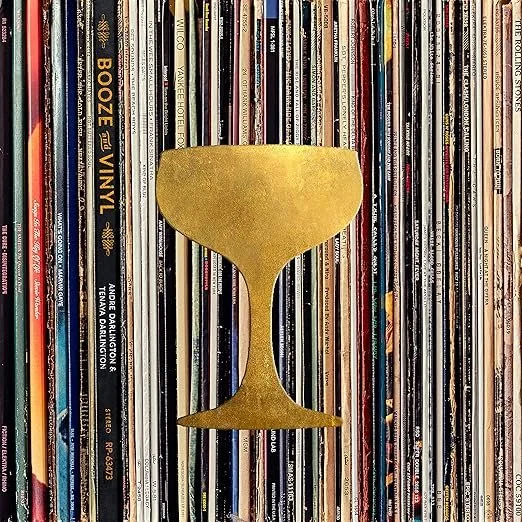Golden cup-shaped object in front of a background of vinyl records.