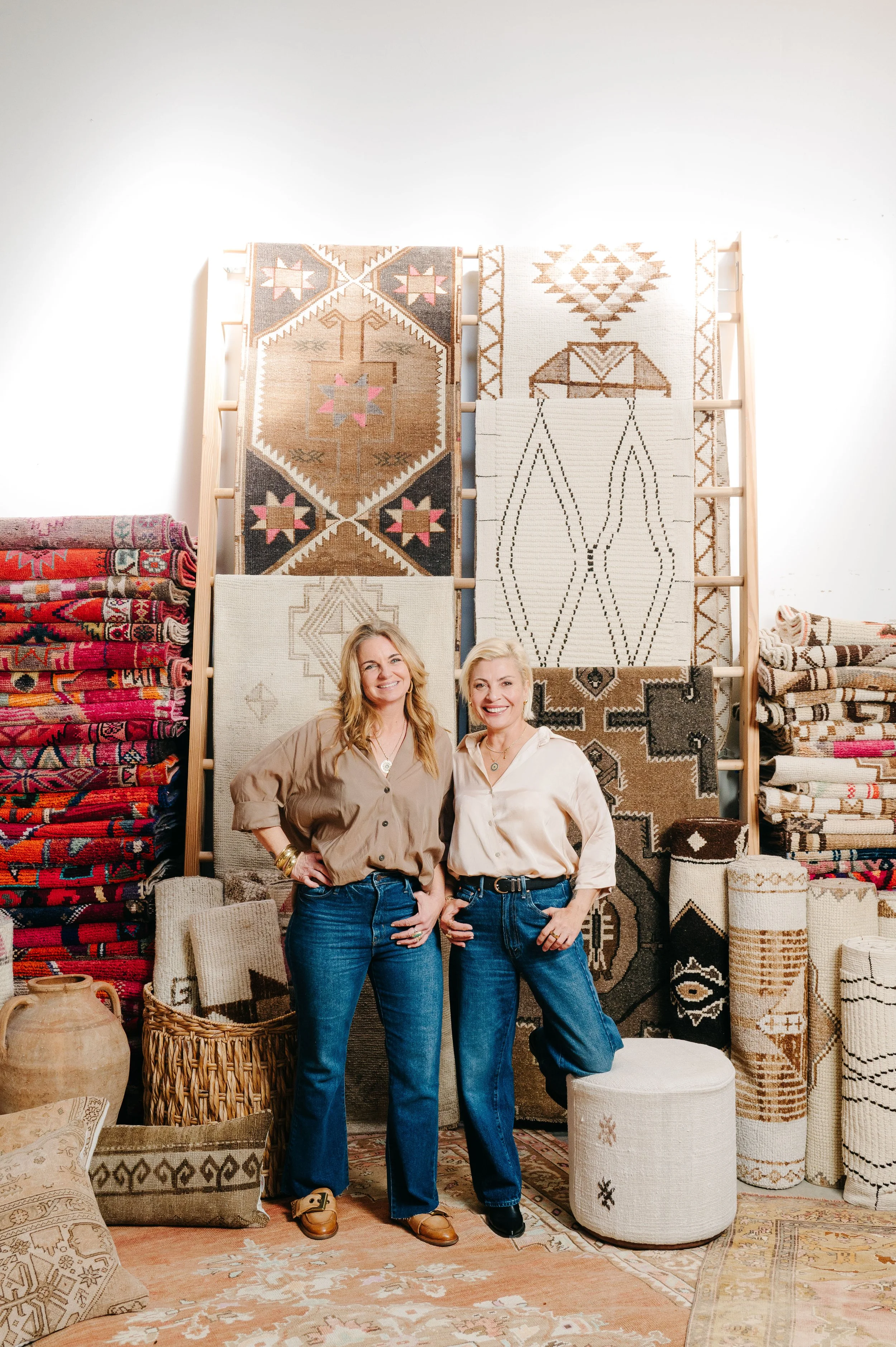 two women in front of rugs