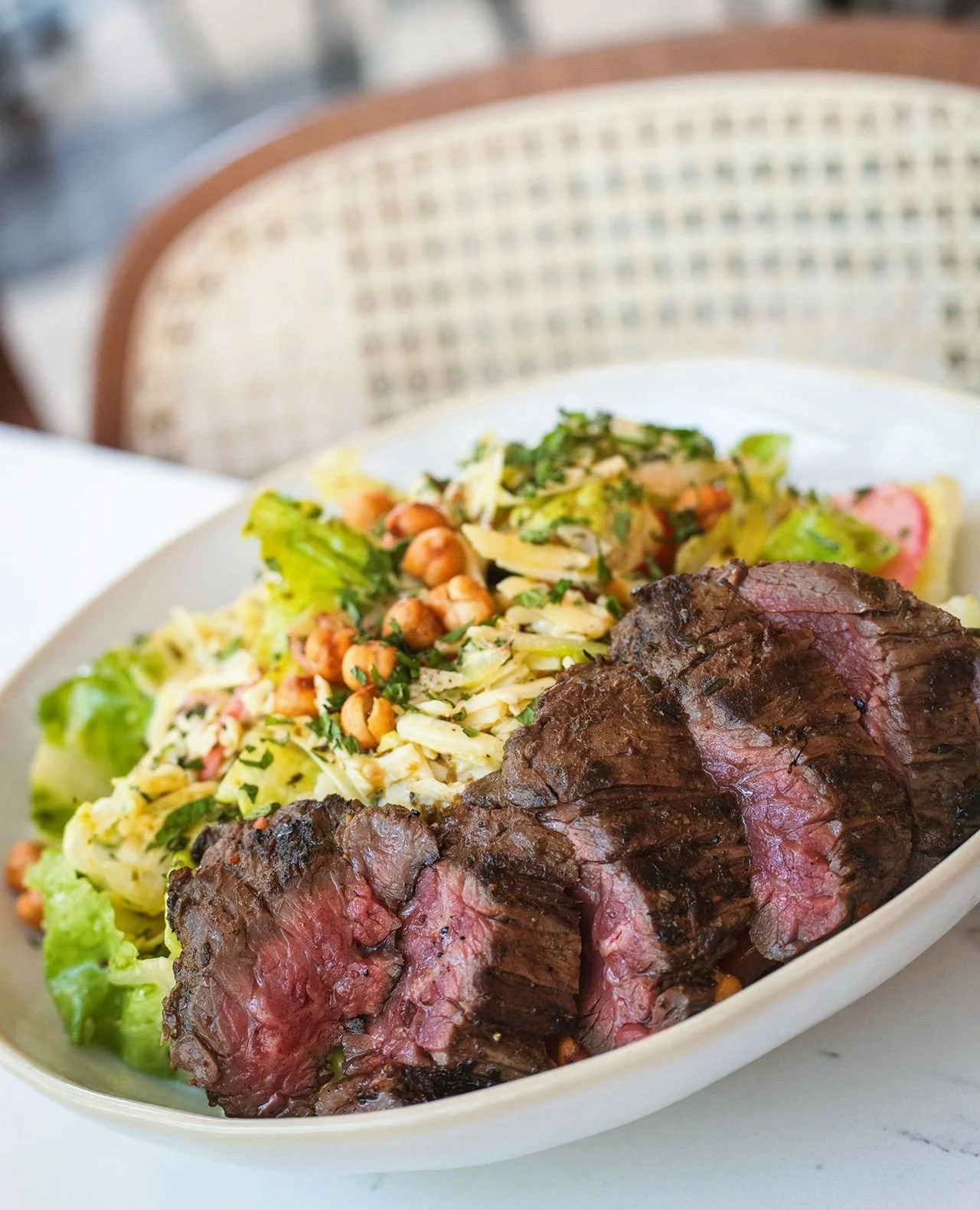 There's no such thing as "just a salad" at Vivienne.⁠
⁠
Our Chopped Salad Vivienne layers crisp romaine with tomato, cucumber, radish, red onion, clothbound cheddar, crunchy chickpeas, and a bright red wine vinaigrette&mdash;and you can top