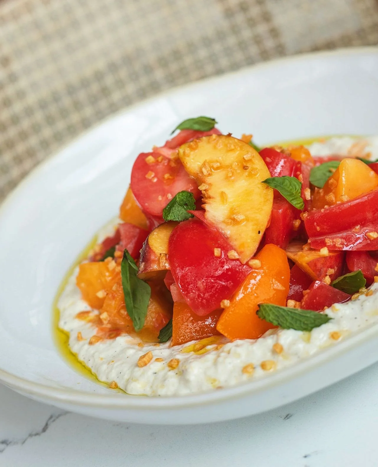Enjoying every last bite of summer 🍅🍑🌿🥒🍓⁠
⁠
Heirloom Tomatoes &mdash; local tomatoes and peaches, basil, mint, lemon-pepper stracciatella, and fried garlic⁠
⁠
Insalata di Zucchine &mdash; raw zucchini, toasted pine nuts, strawberries, charred re