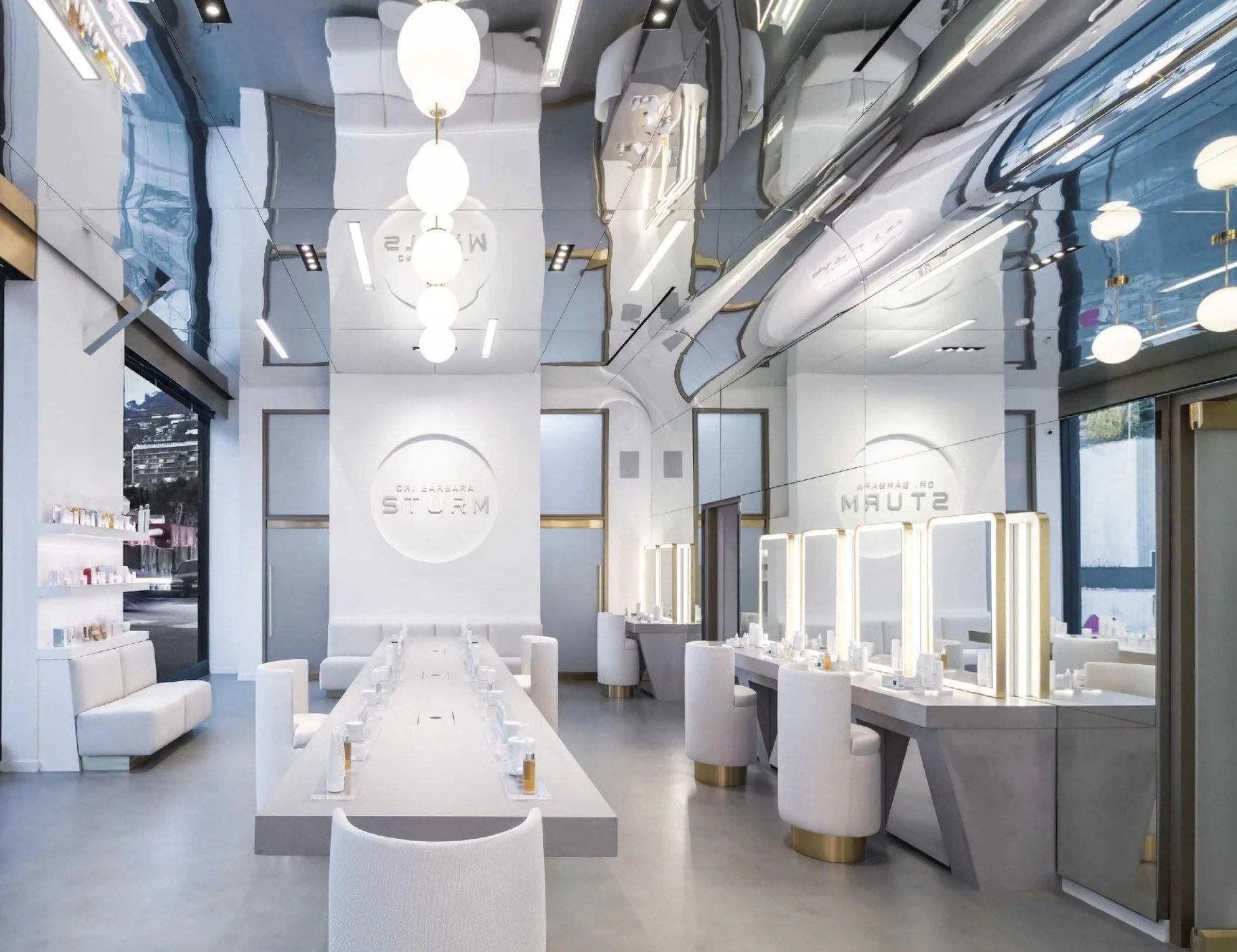 Empty modern beauty salon with white chairs, mirrors, and lighting fixtures, large windows with city view, and a sign that reads "Dr. Barbara Storm."