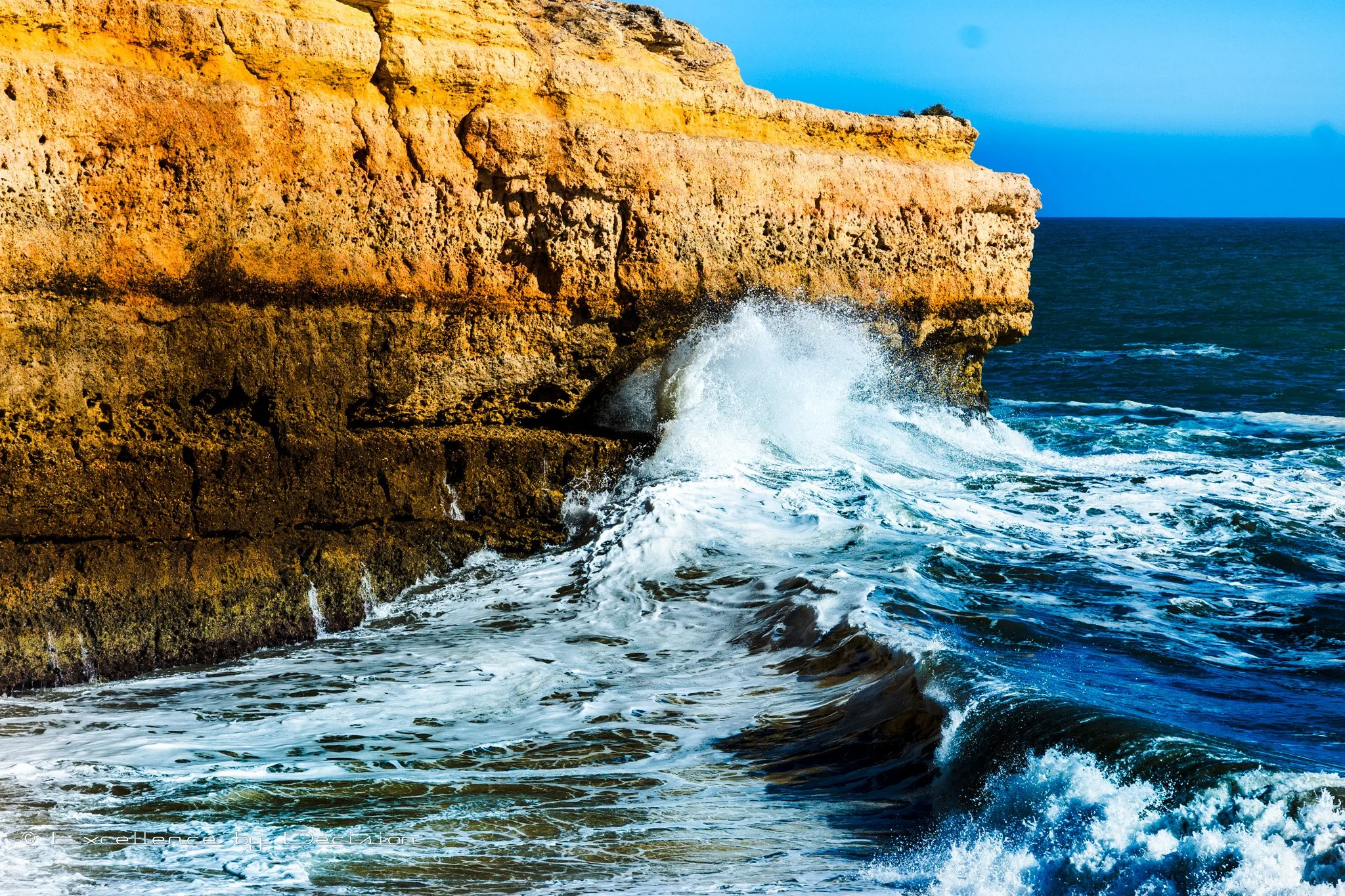 Ocean waves crashing against a rocky cliff.