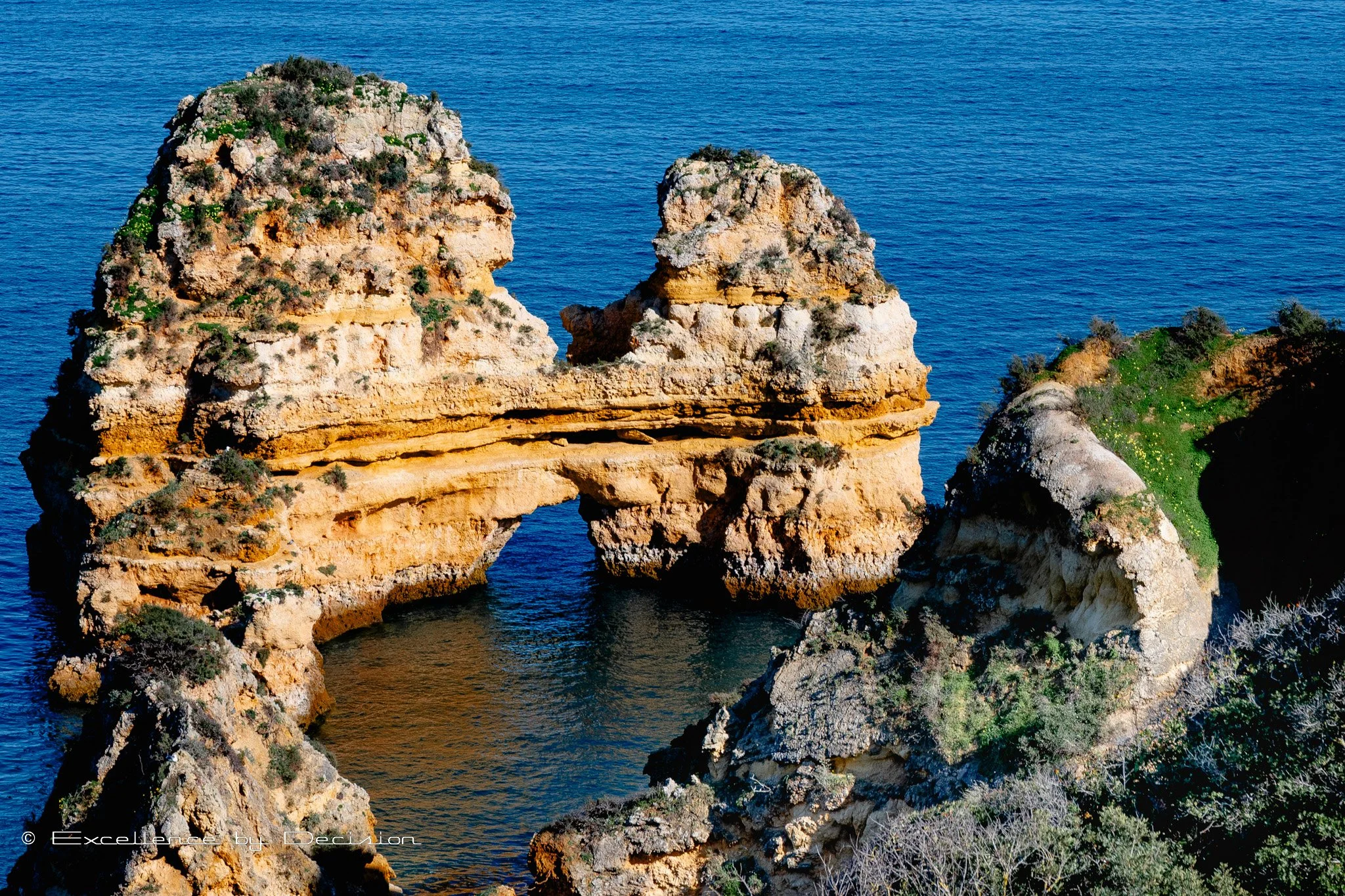 Rock formations and cliffs with vegetation by the blue sea