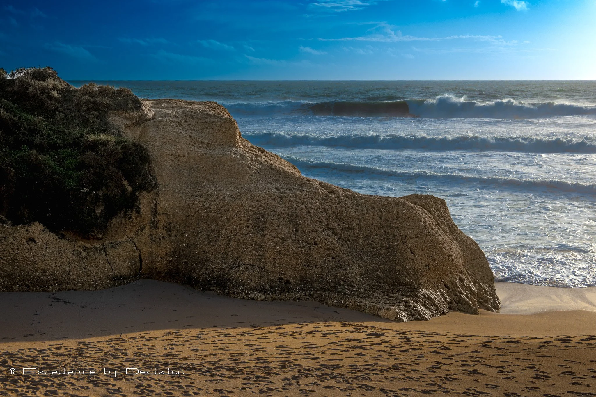 Rocky beach with ocean waves and blue sky