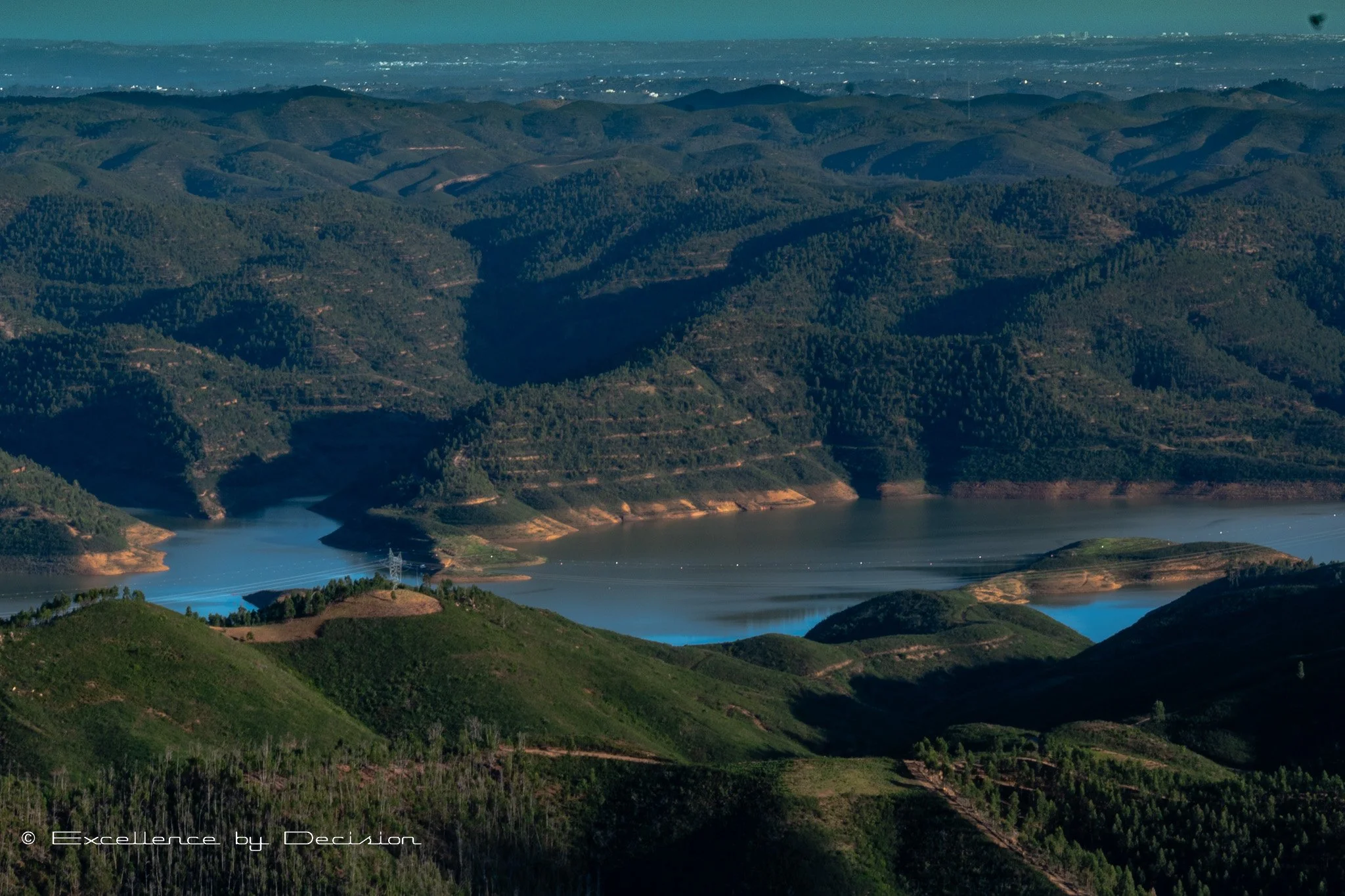 Scenic view of a reservoir surrounded by forested hills