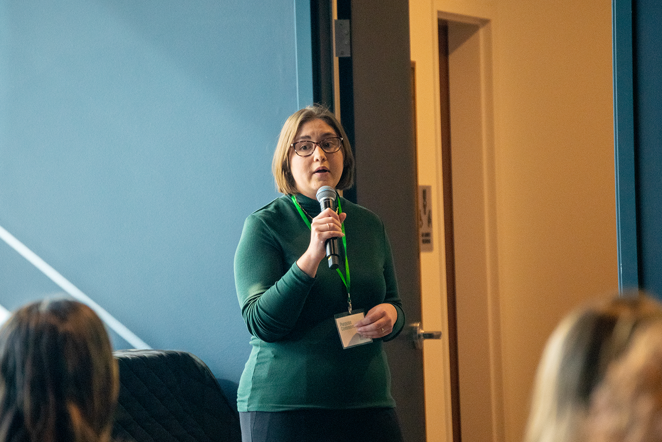 A woman gives a talk in front of an audience at a conference