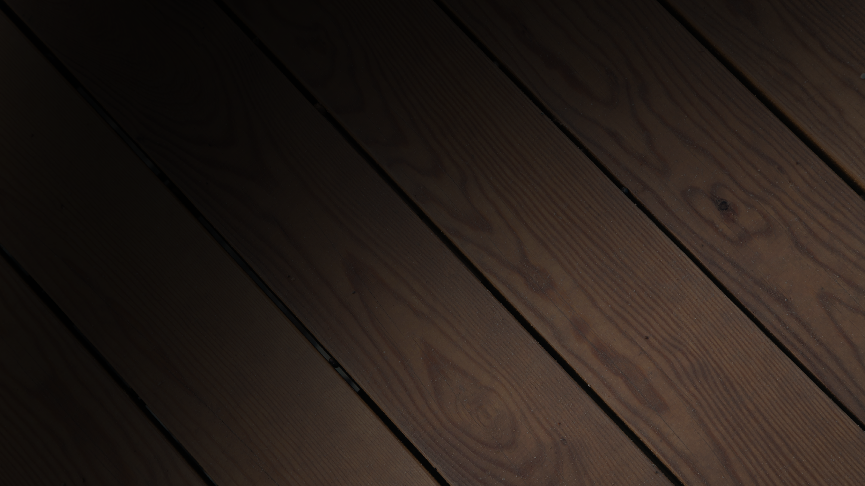 Dark wooden deck boards with visible grain pattern.