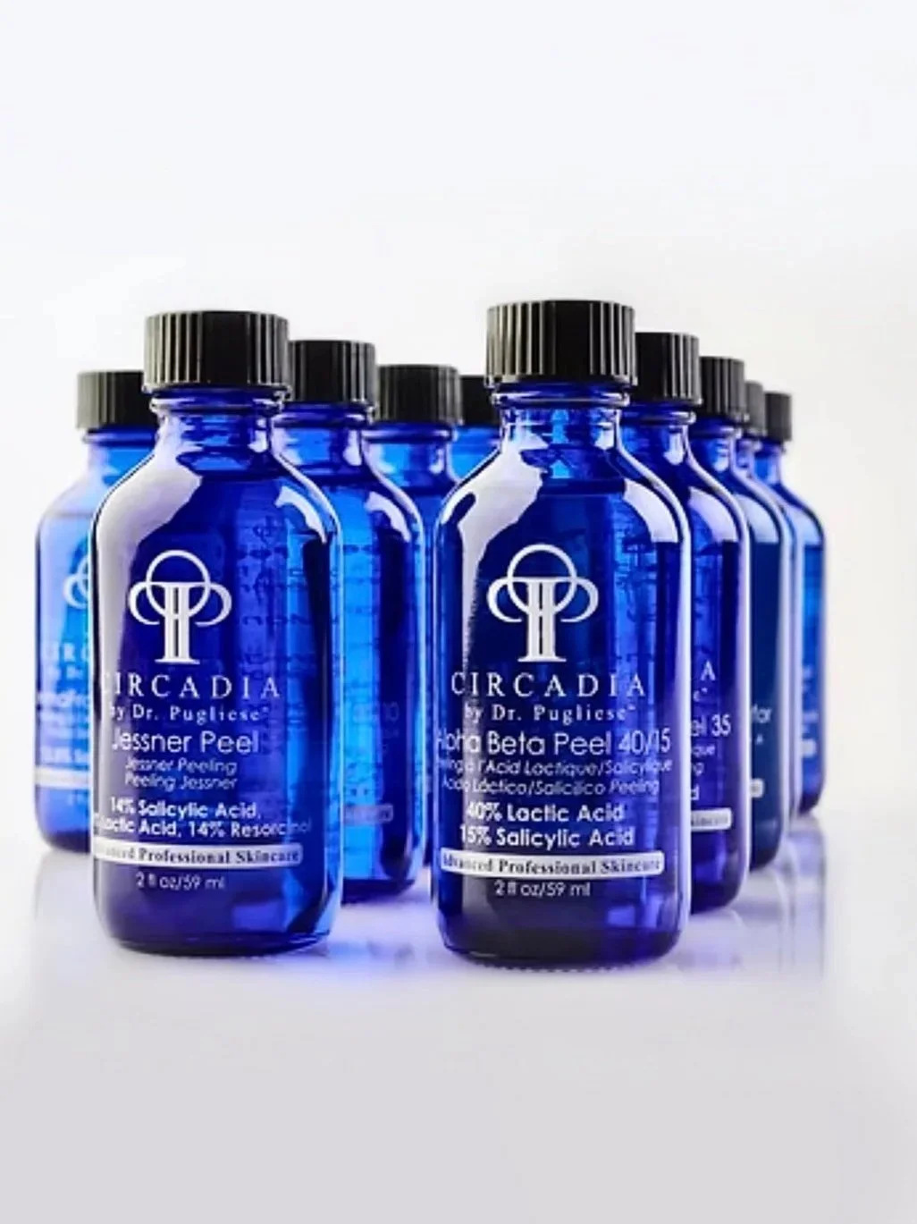 Group of blue bottles labeled Circadia by Dr. Pugliese, containing 40% lactic acid and 15% salicylic acid, arranged in a pyramid shape.
