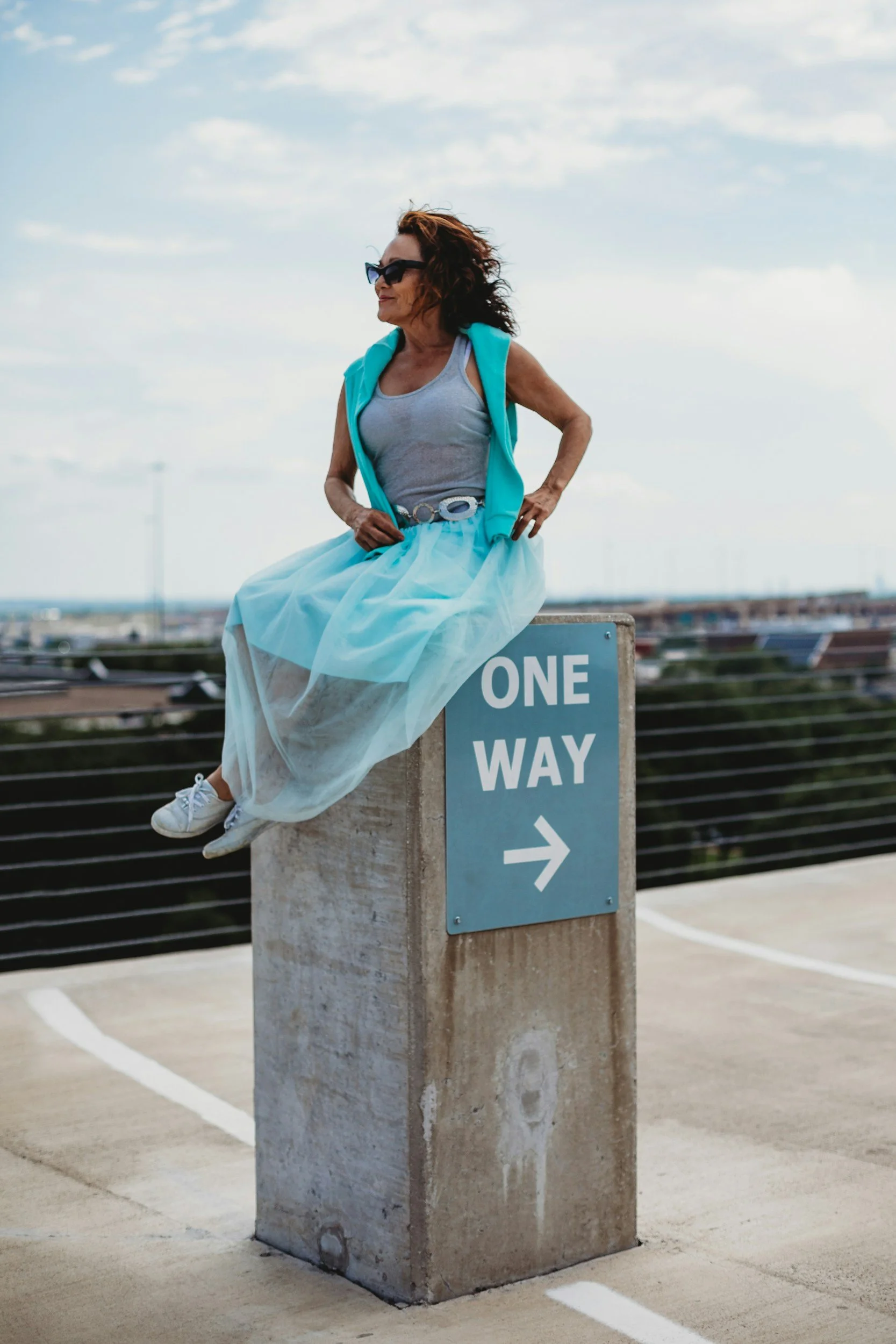 A Strong Woman Sitting On A One Way Sign, Choosing To Go Her Own Way And Choose Personalized Skin Transformation Built on Science, Not Hype, for Menopausal Woman.