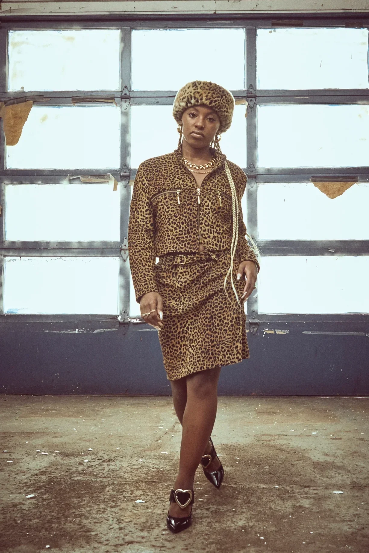 Woman wearing a leopard print vintage matching set walking in an industrial setting, showcasing curated sets from the Fashion to the People Premium Vintage collection.
