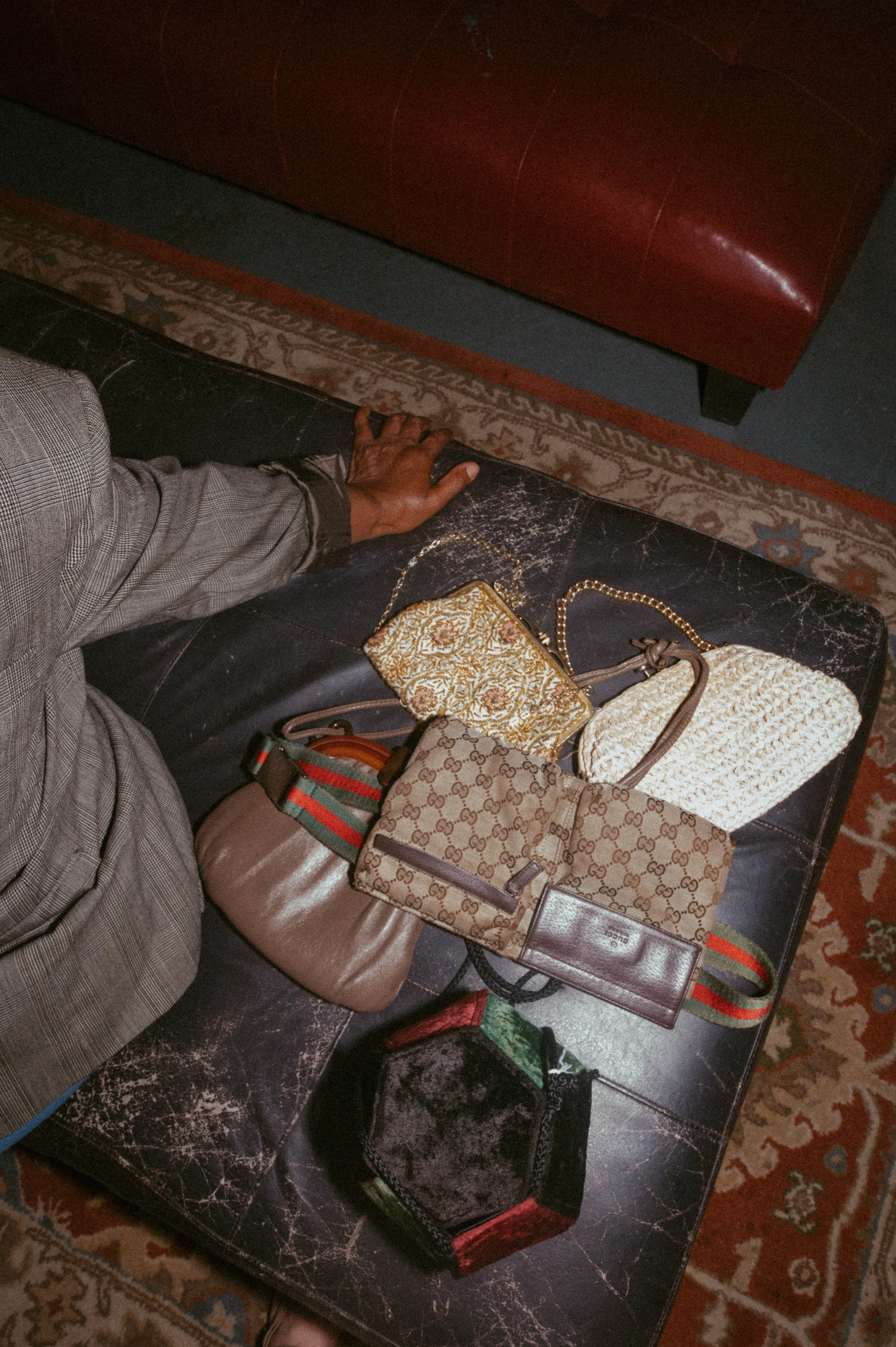 A curated arrangement of vintage designer handbags and accessories displayed on a leather surface, highlighting texture, craftsmanship, and the timeless appeal of archival fashion pieces.