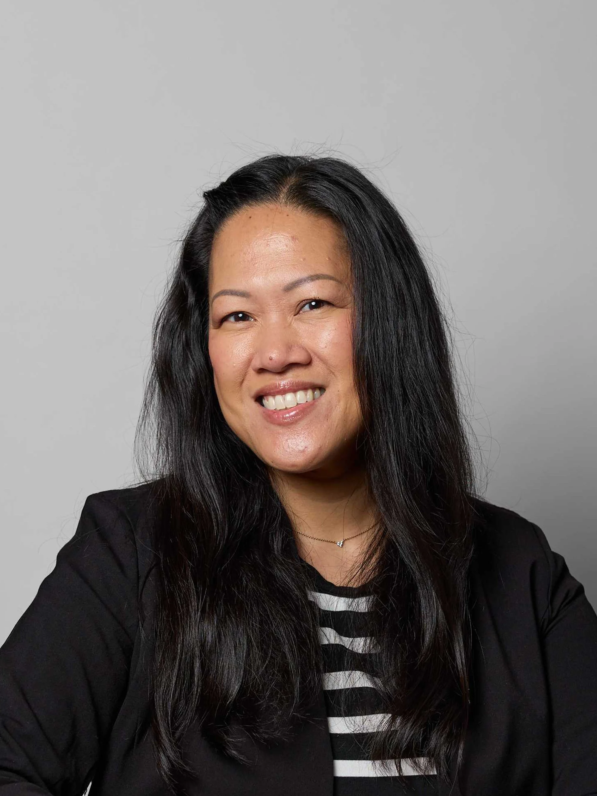 Maureen Laventure, smiling in front of a dark background.