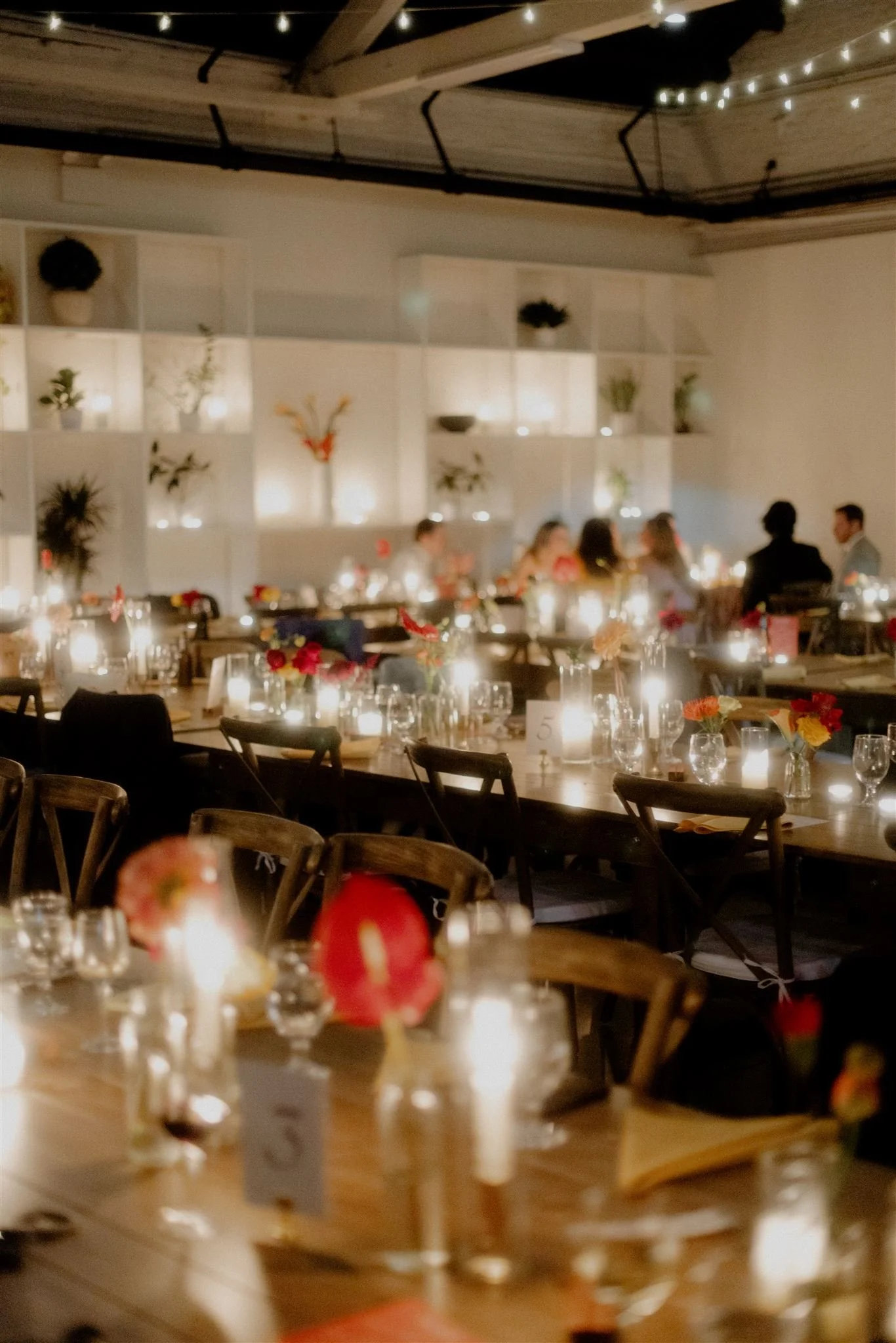 Main room decorated with table settings and floral centerpieces.