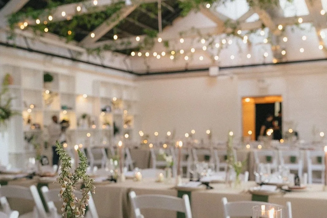 Main room decorated with table settings and floral centerpieces.