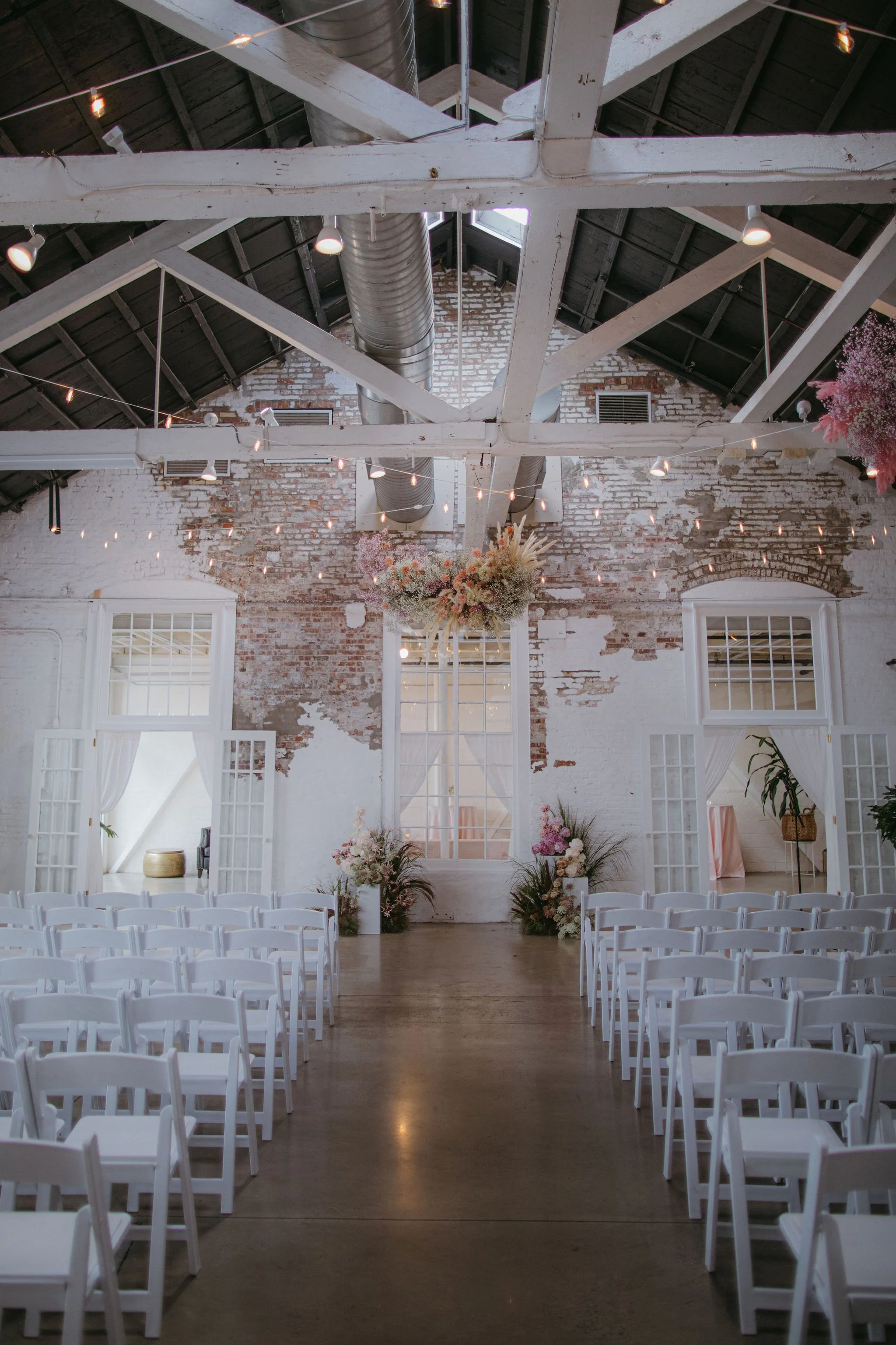 Interior view of Hamilton Loft showing exposed brick walls, high ceilings, skylights, and wooden floors.
