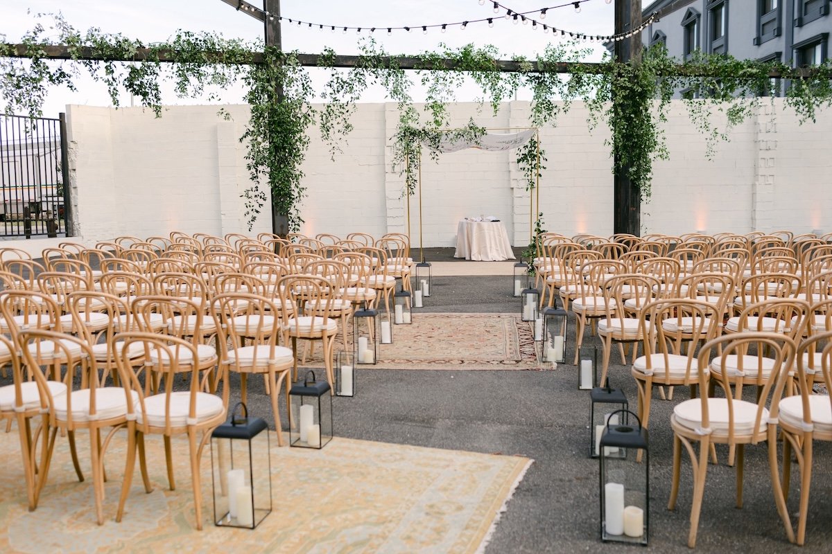 Outdoor pre-ceremony setup with chairs and aisle.
