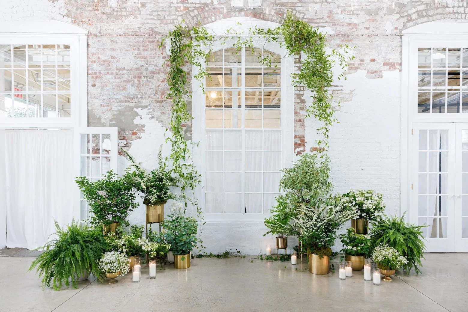 Pre-ceremony setup with hanging greenery and exposed brick.

