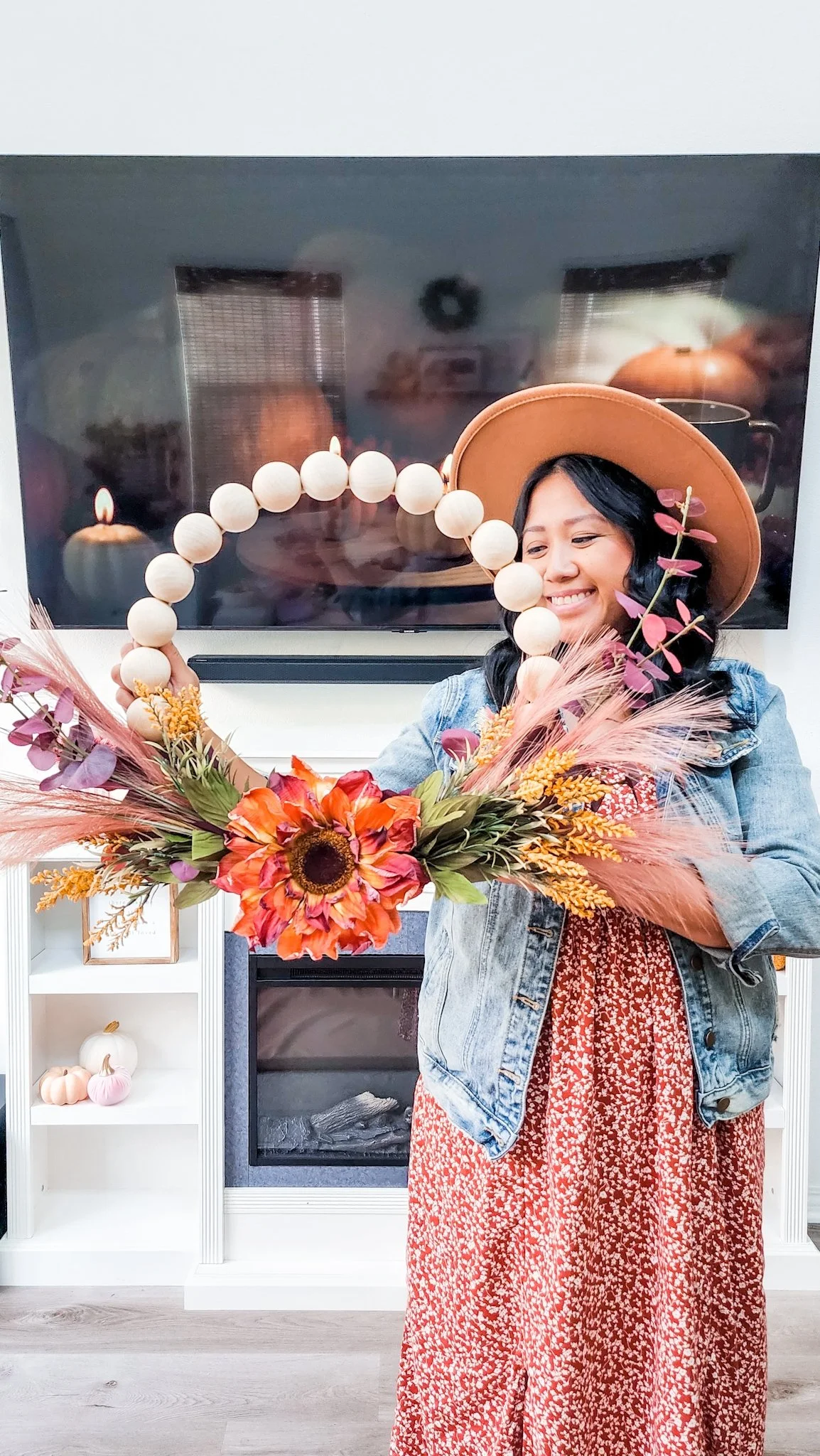 Woman holding DIY Fall Harvest Wood Bead Wreath