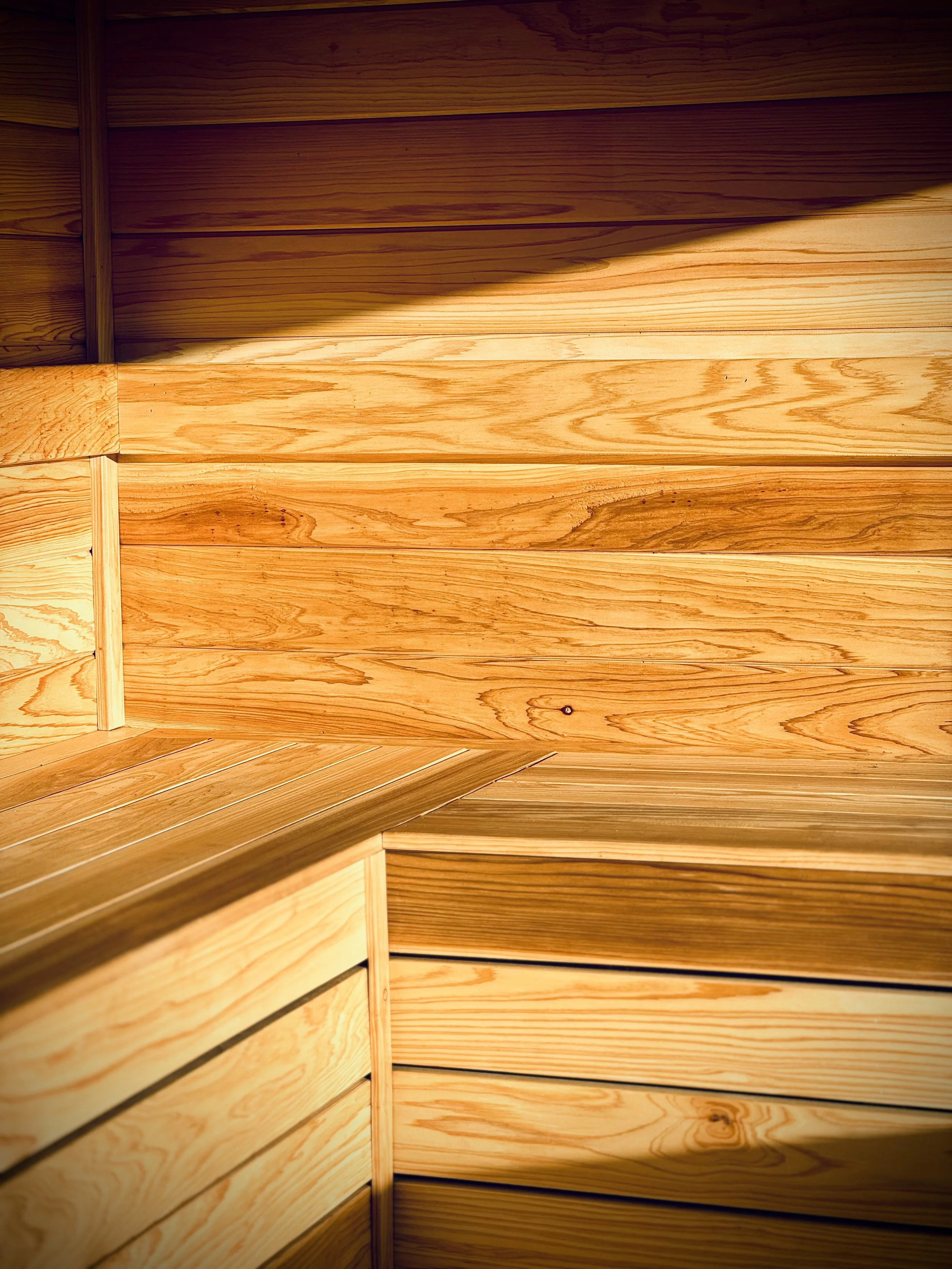 Close-up of wooden interior with horizontal panels and corner with overlapping wood planks.