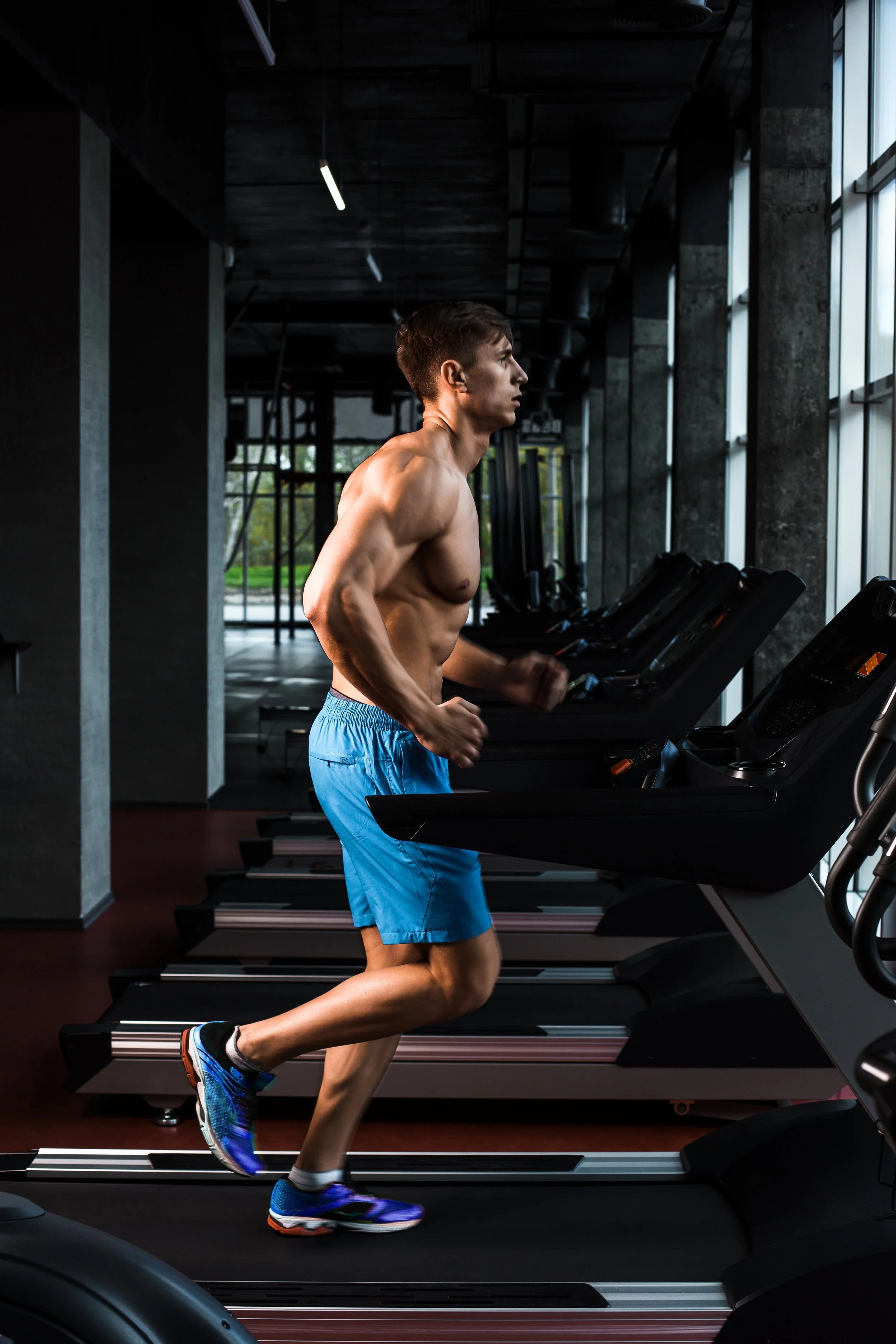 side-view-full-length-young-man-sportswear-running-treadmill-gym-muscular-young-man-blue-shorts-doing-exercises-motion-blur.jpg