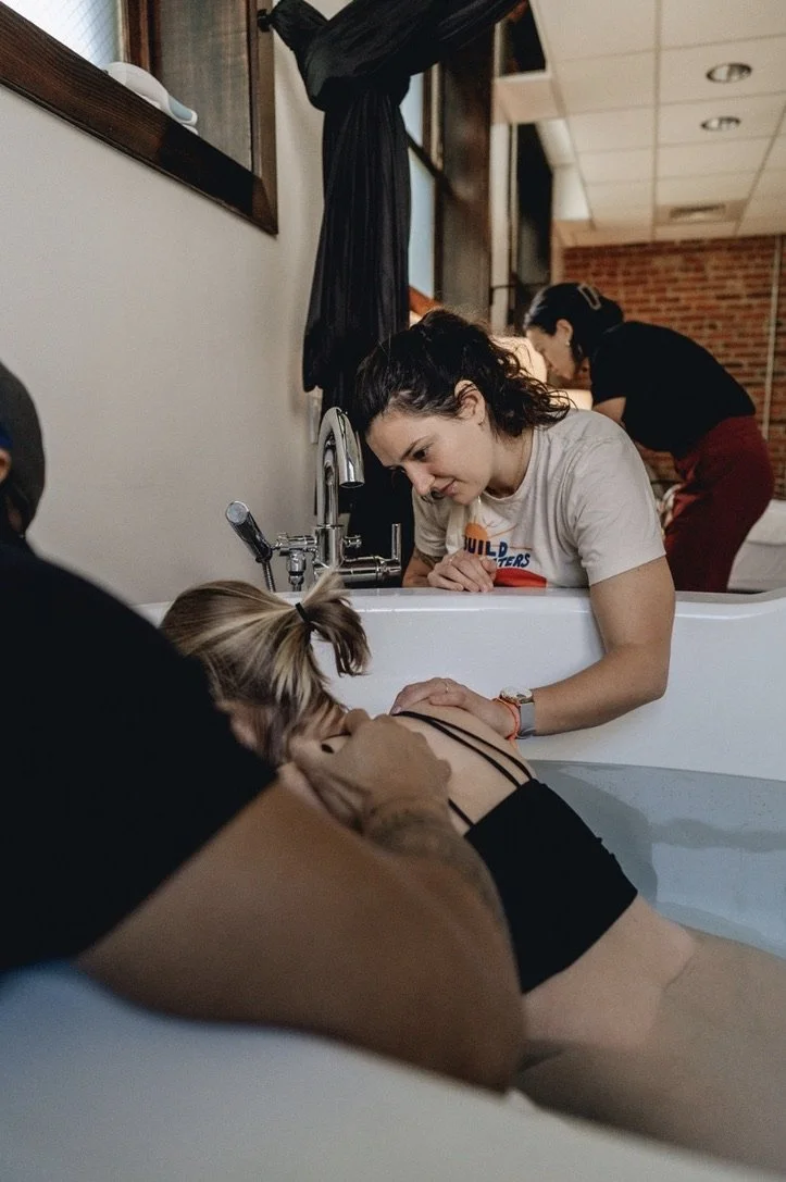 queer doula chicago mel haley supporting a labor during a waterbirth in a tub
