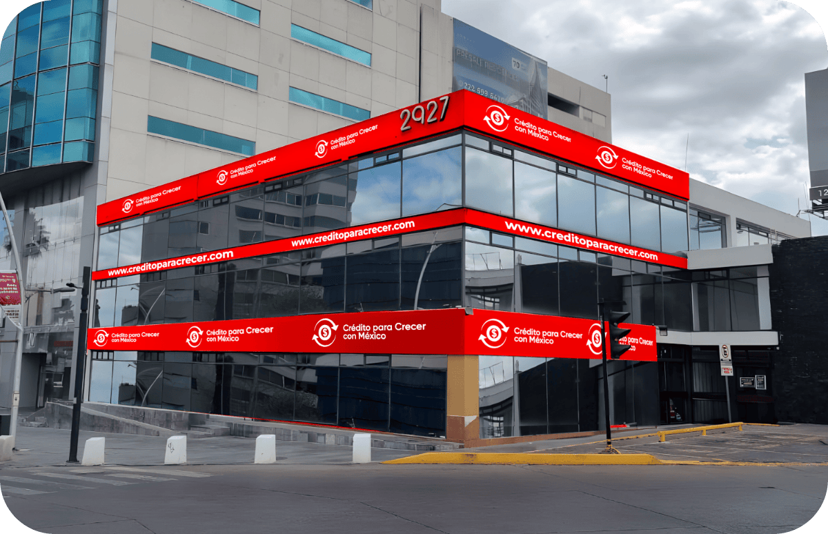 Edificio de oficinas con pantallas digitales rojas que muestran el texto en español y la página web de un banco mexicano.