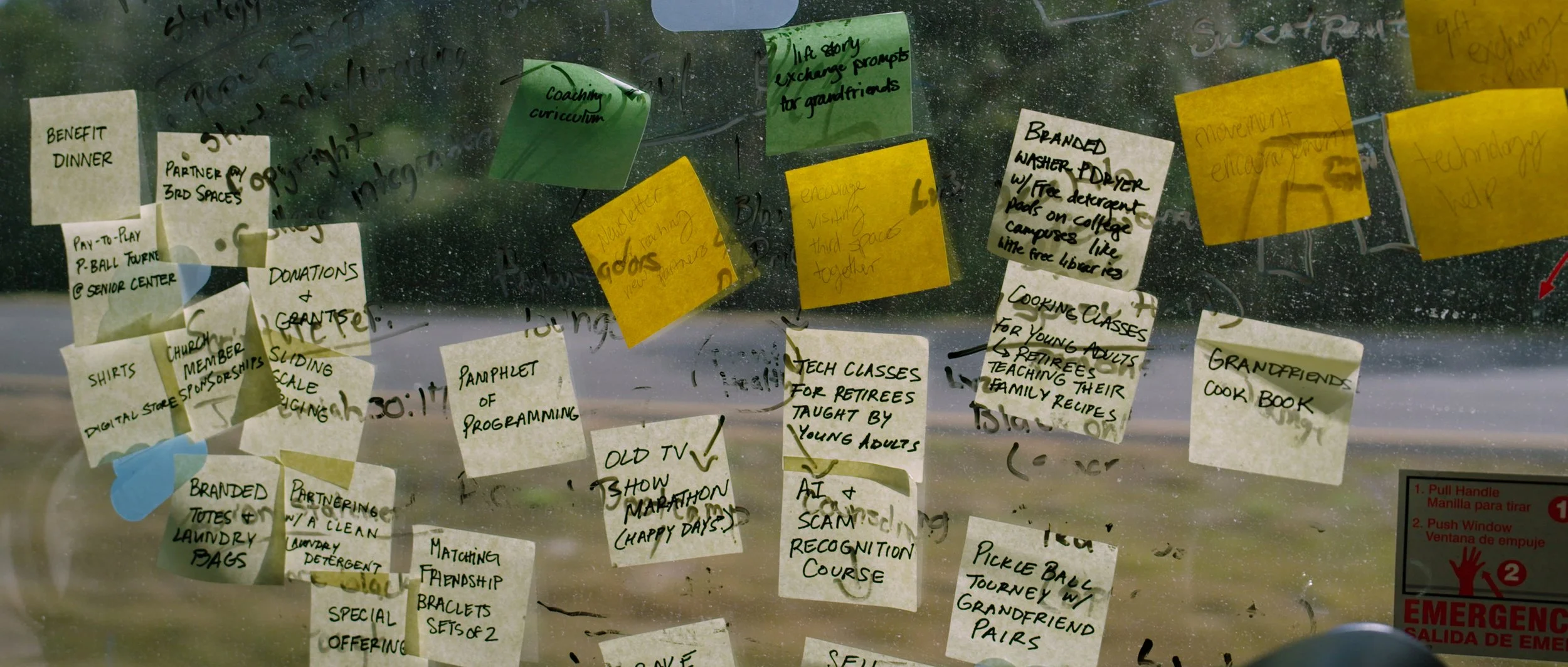 Several colorful sticky notes with handwritten notes attached to a glass window. The notes include various plans and reminders.