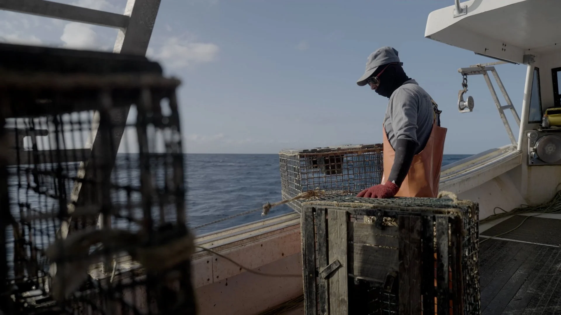 Fisherman on boat with lobster traps on open sea