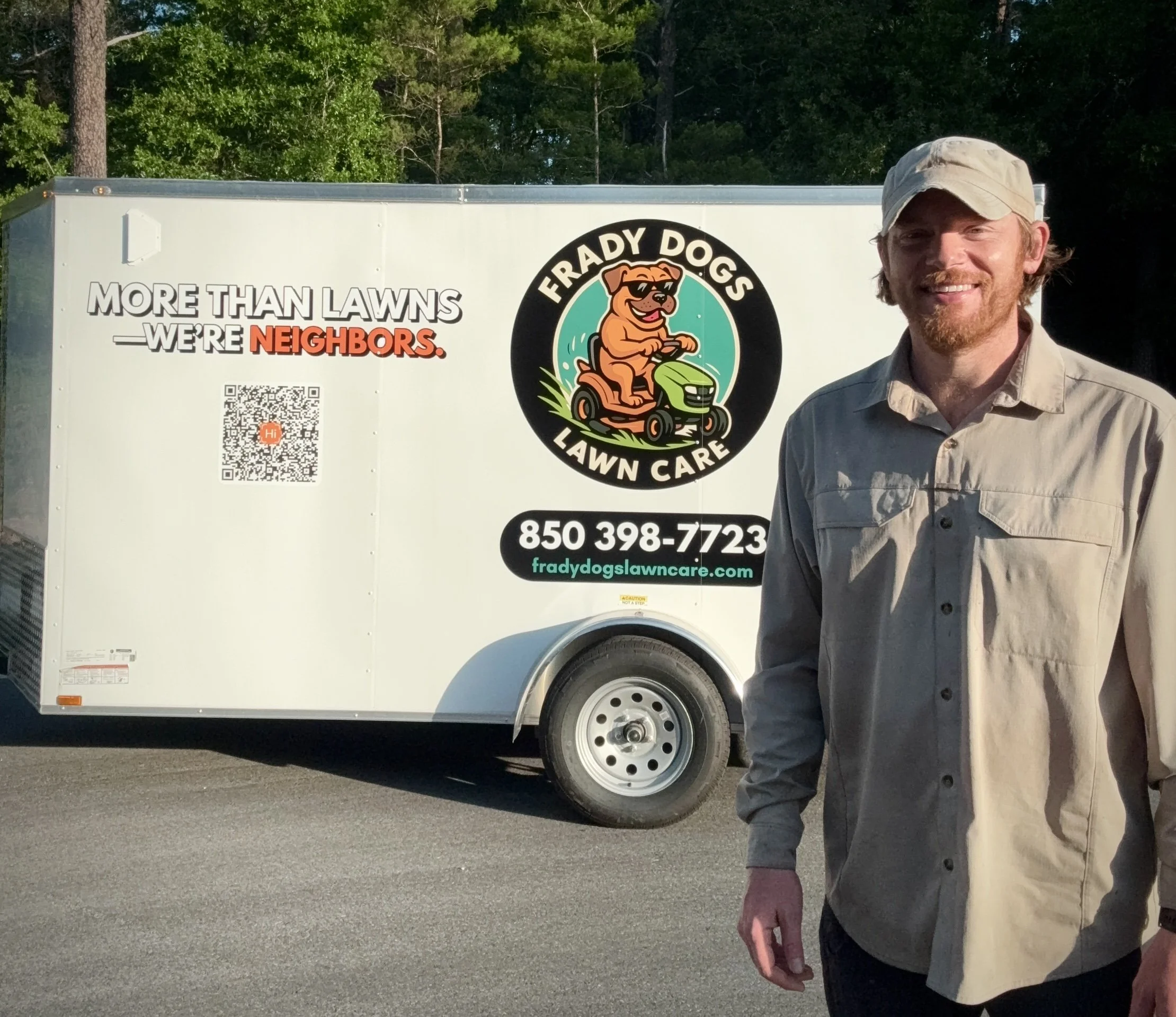 Shawn Frady of Frady Dogs Lawn Care standing next to the branded service trailer in Niceville, FL featuring the company logo and neighborhood-focused slogan.