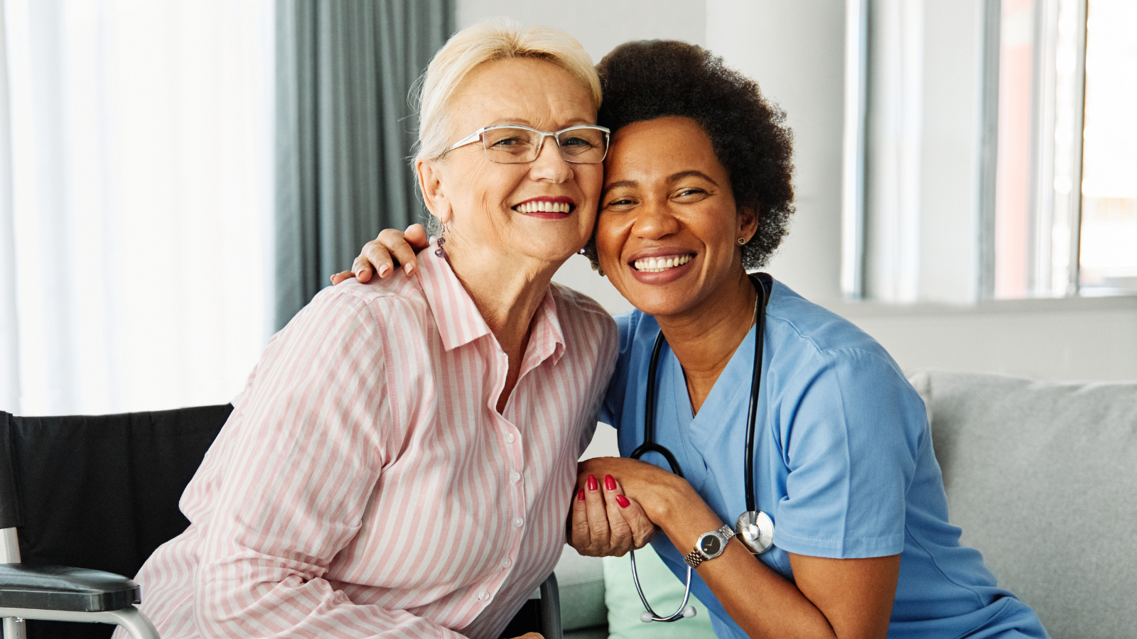 A nurse and elderly woman smiling for the camera