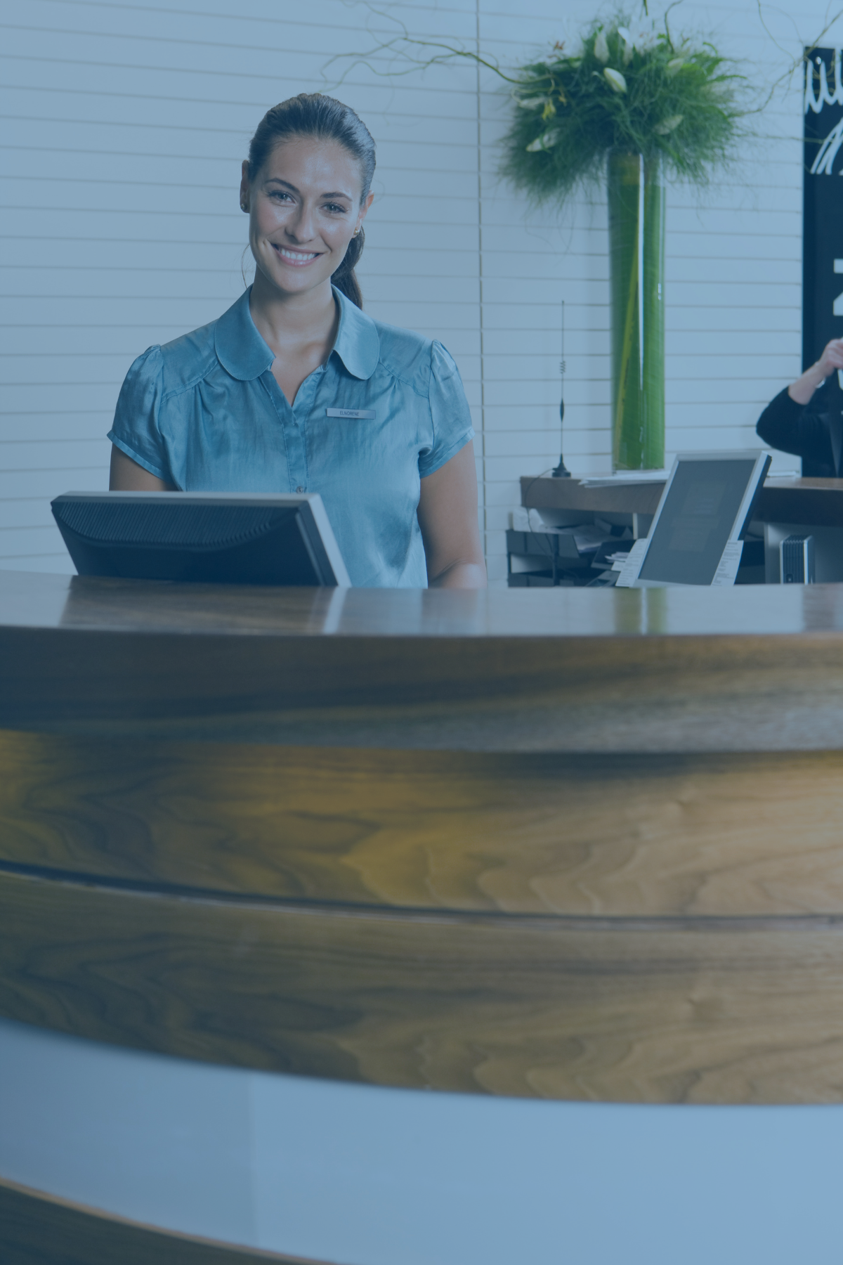 Front desk staff member smiling behind the desk