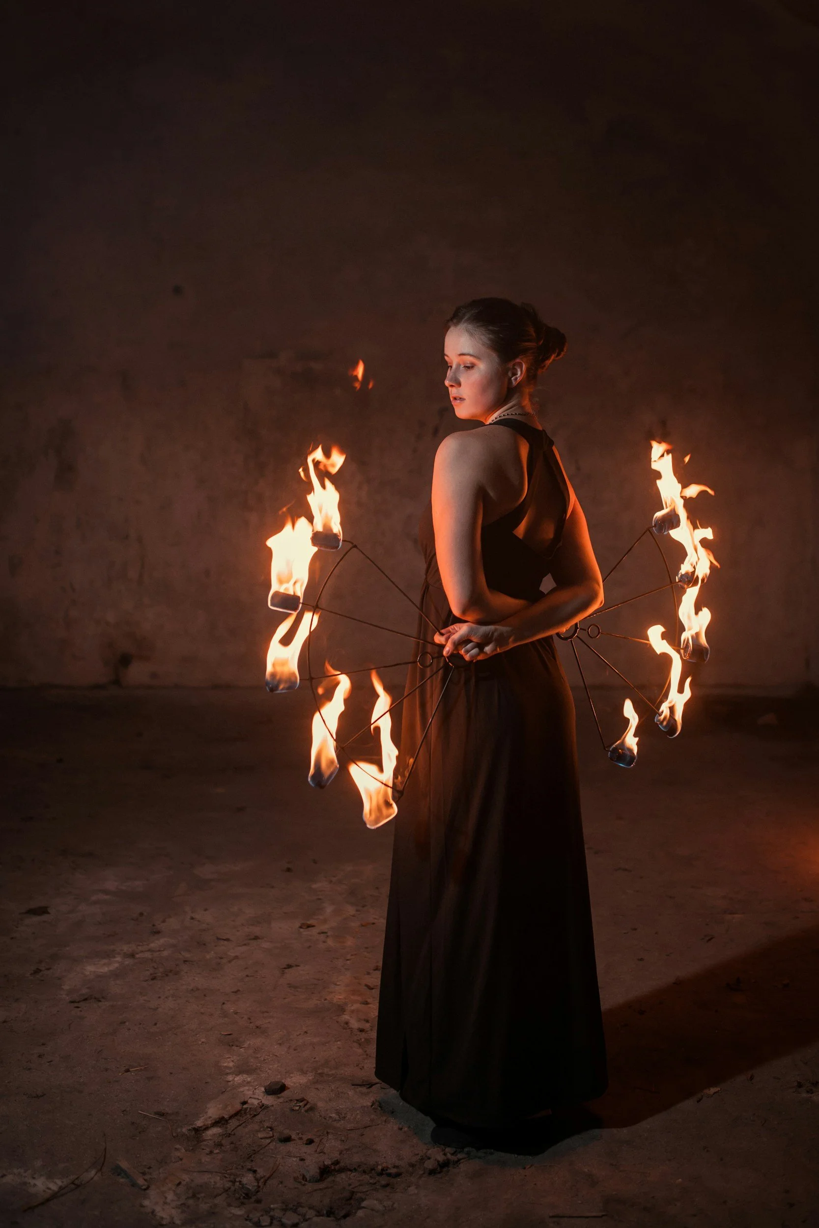 Performer posing with fire fans, ready to deliver a captivating flame performance for guests.