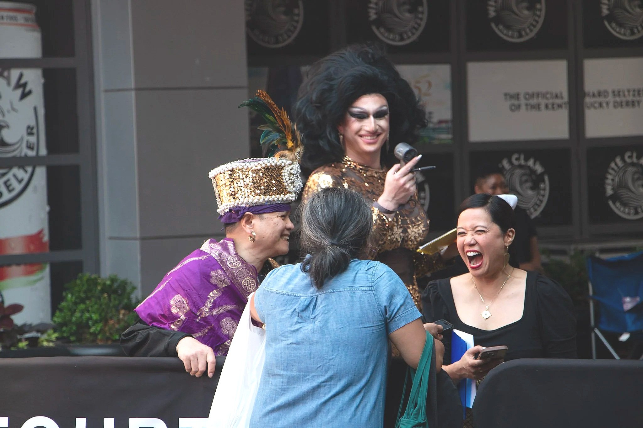 Tomas Bacala, Jemma Fetalver, and Umi Naughty laugh with a festival attendee. (Photo by McKenzie Gary, 2026.)