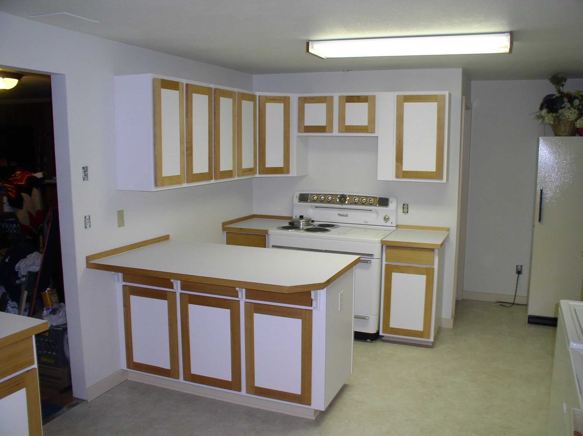 Retro kitchen with white cabinets, wood trim, and a vintage stove.