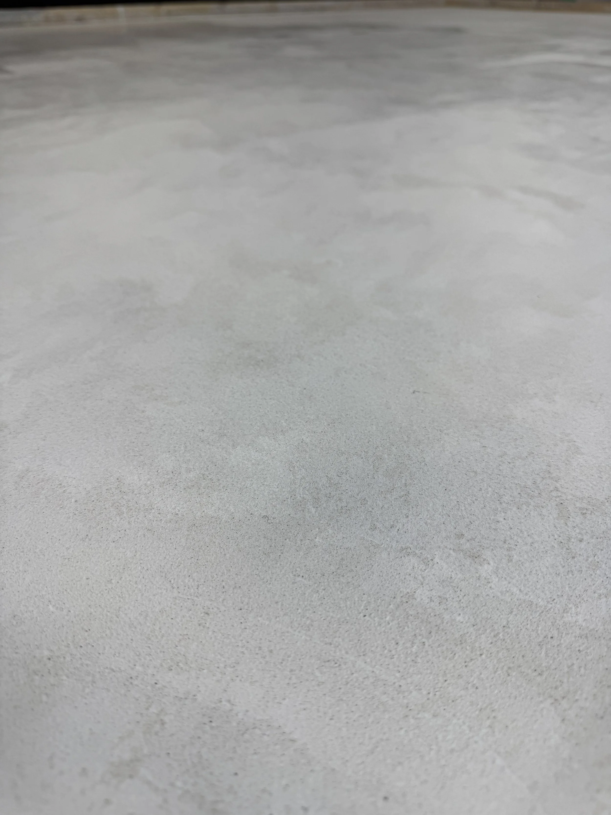 Close-up of a smooth, light-colored microcement floor.