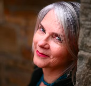 Close-up of a woman Dr Gemma Turner, experienced voice tutor with a phd. Multi-instrumentalist, multi-linguist, singer songwriter and choir director