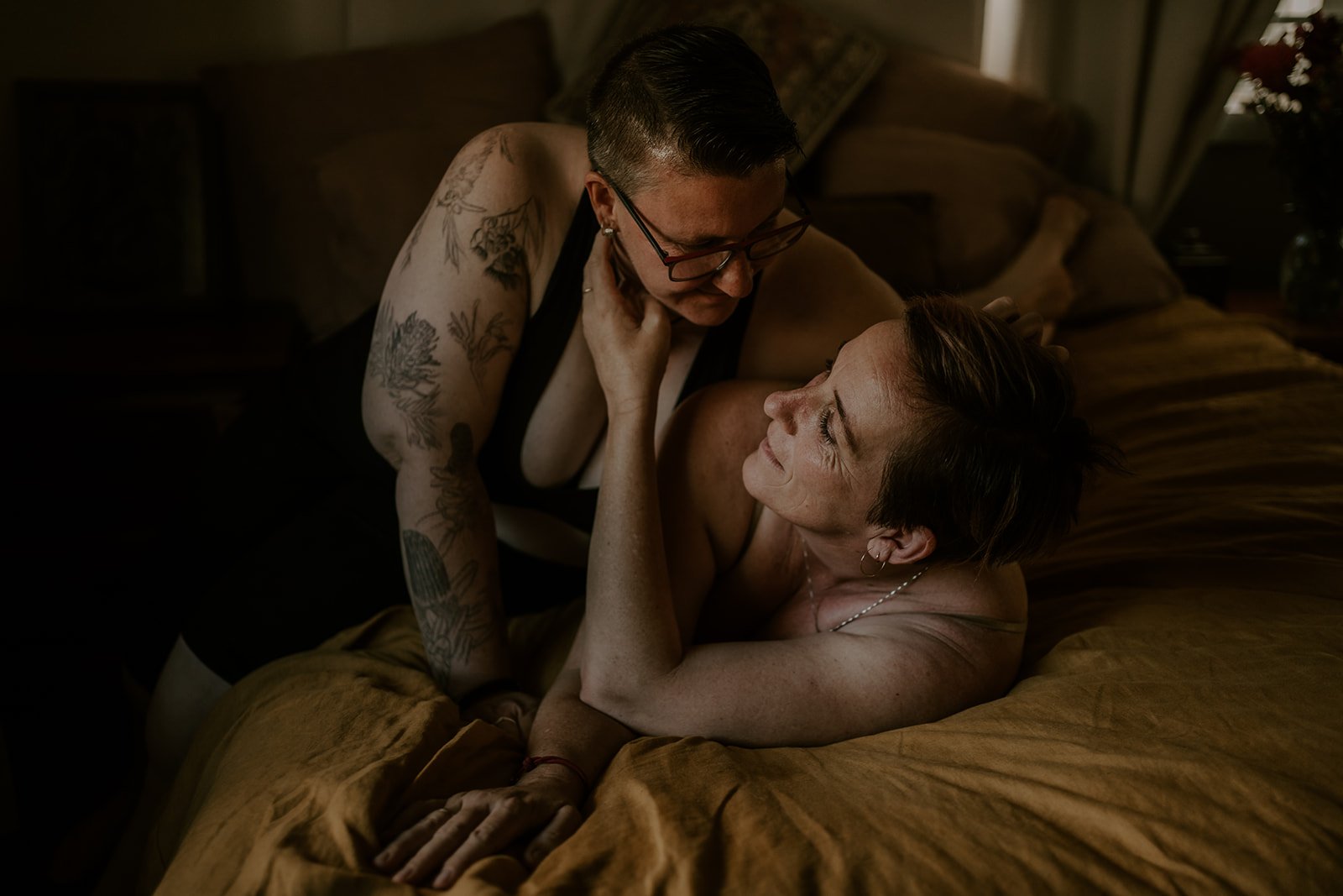 queer couple in a loving embrace on the bed